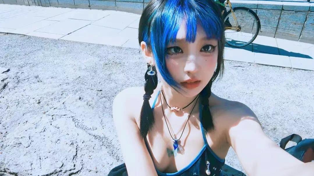 蓝头发和项链的女人为一张照片。