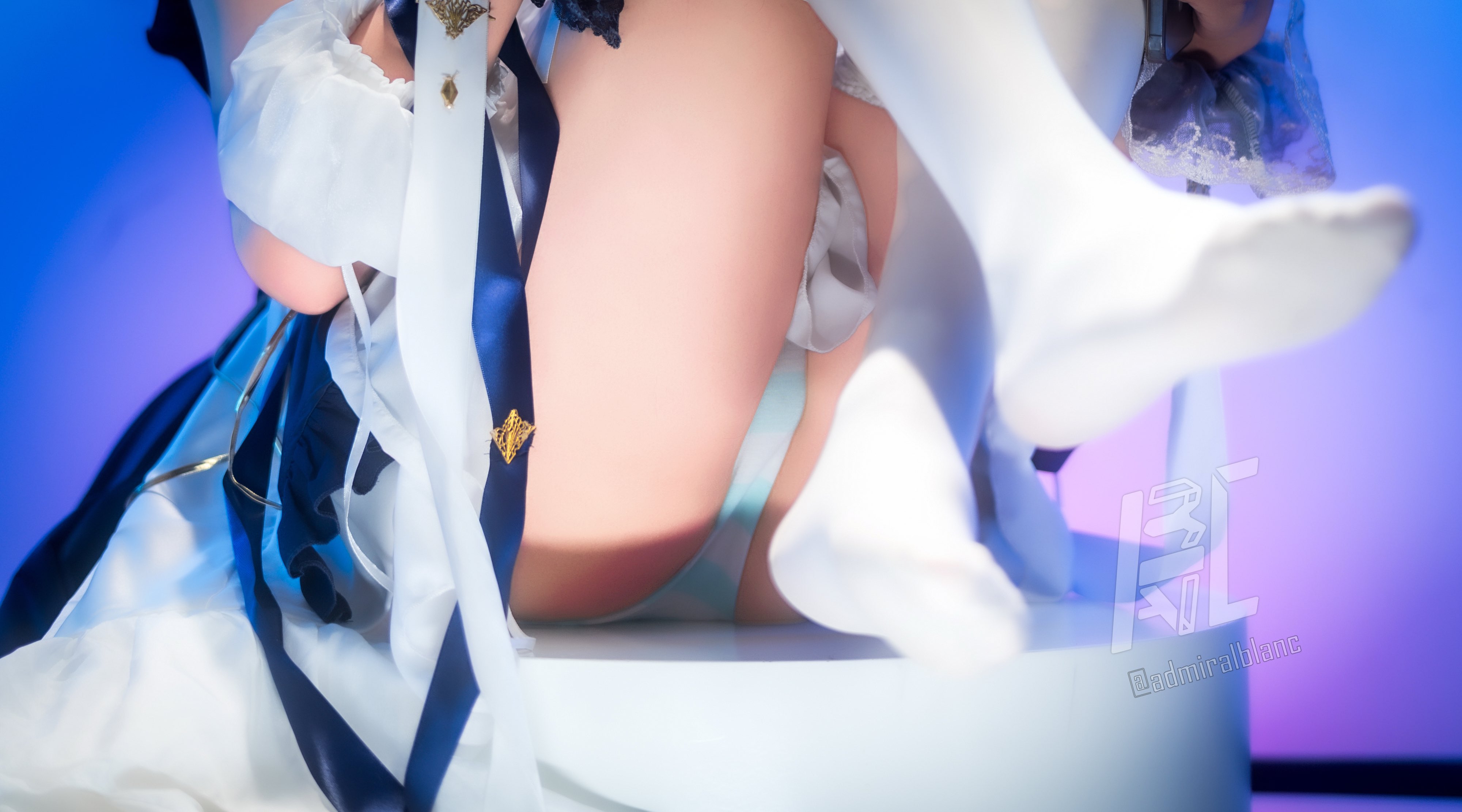 女人穿着一件白色裙子,带有蓝色带。