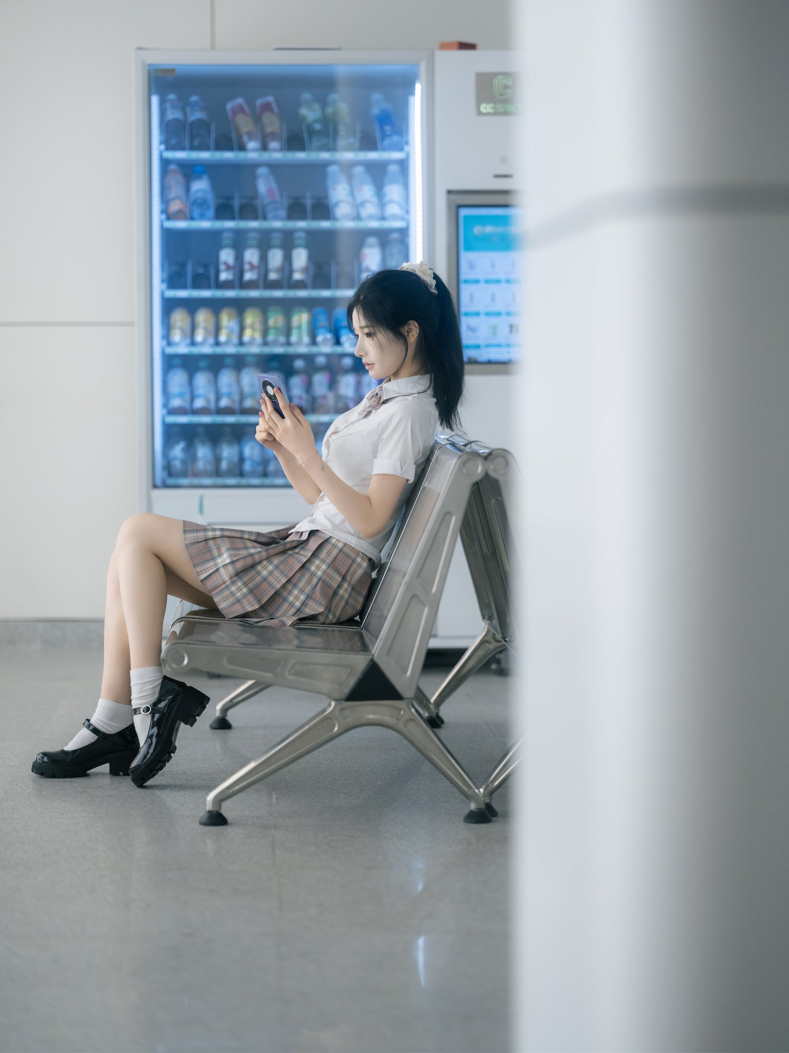 女孩坐在冰箱前面的椅子上。