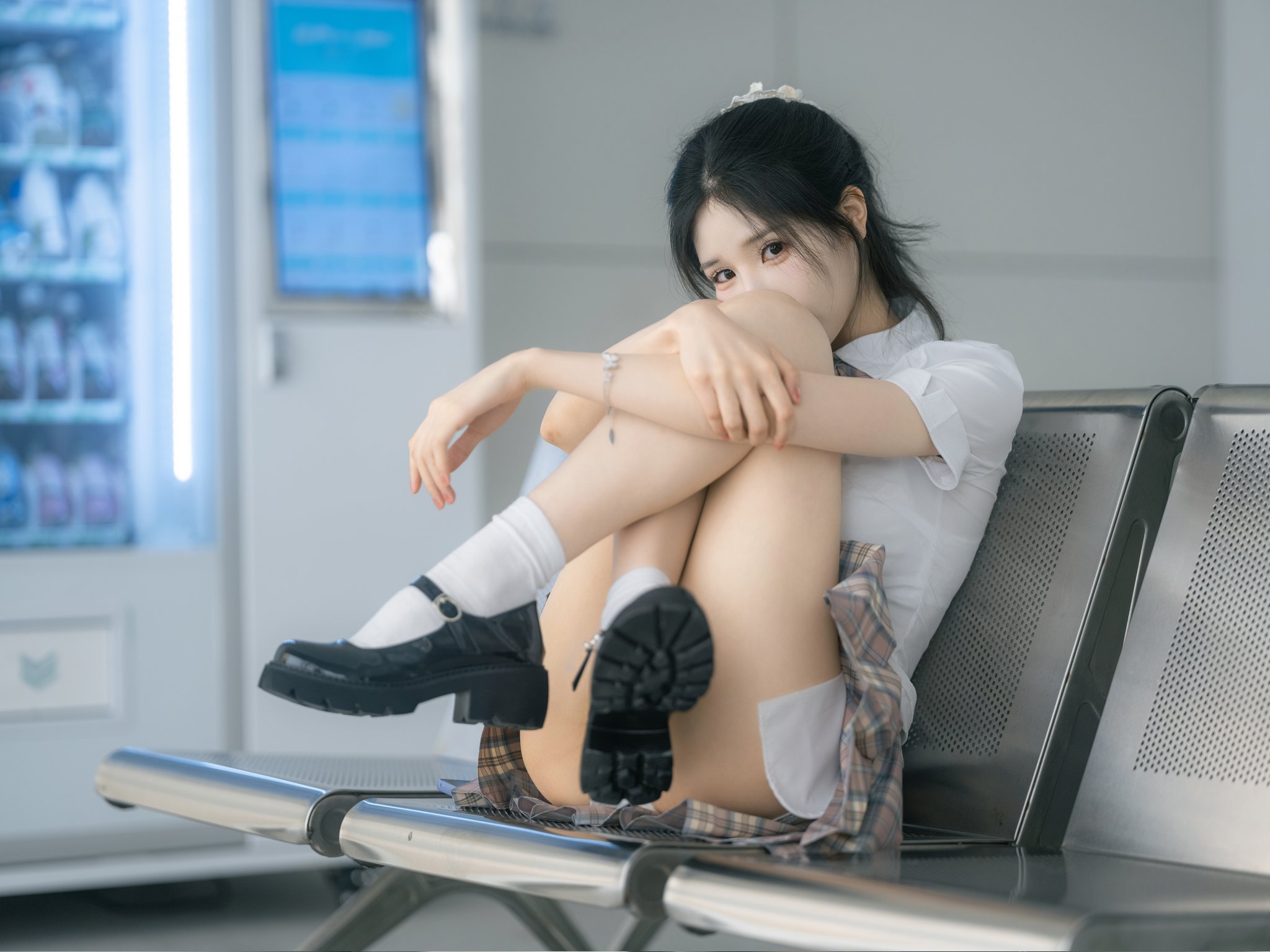 女孩坐在冰箱前面的椅子上。