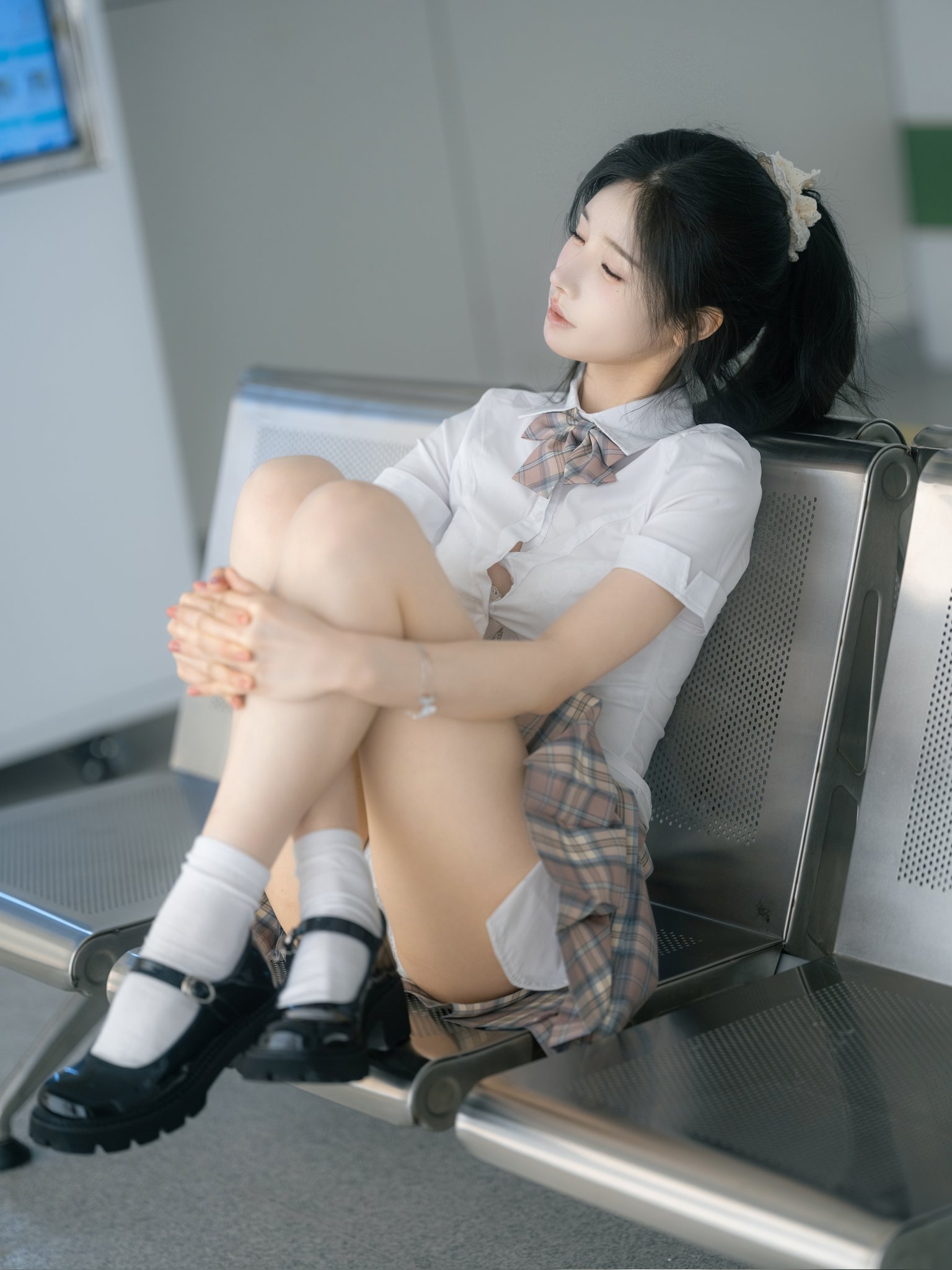 女孩坐在冰箱前面的椅子上。