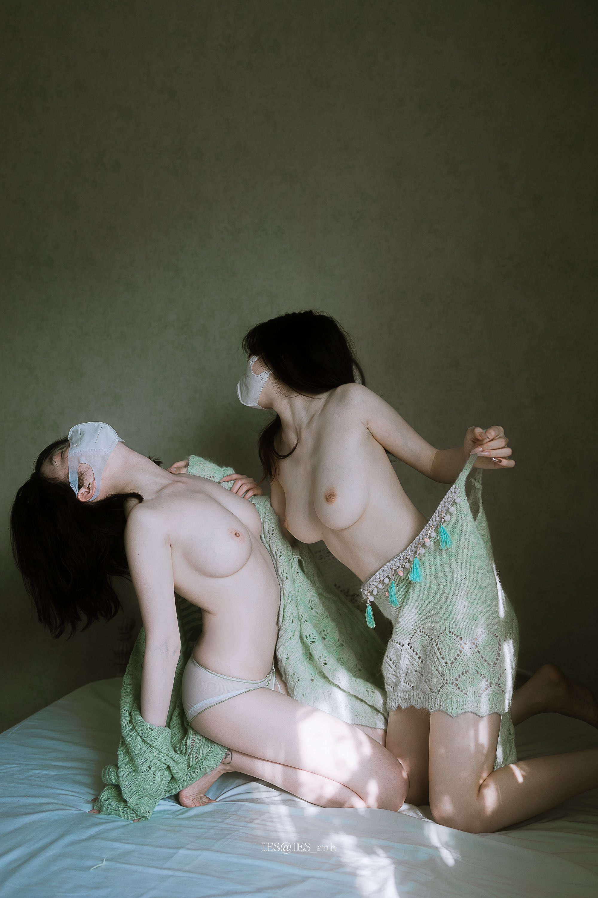 两个女人在卧室里,戴着面具。