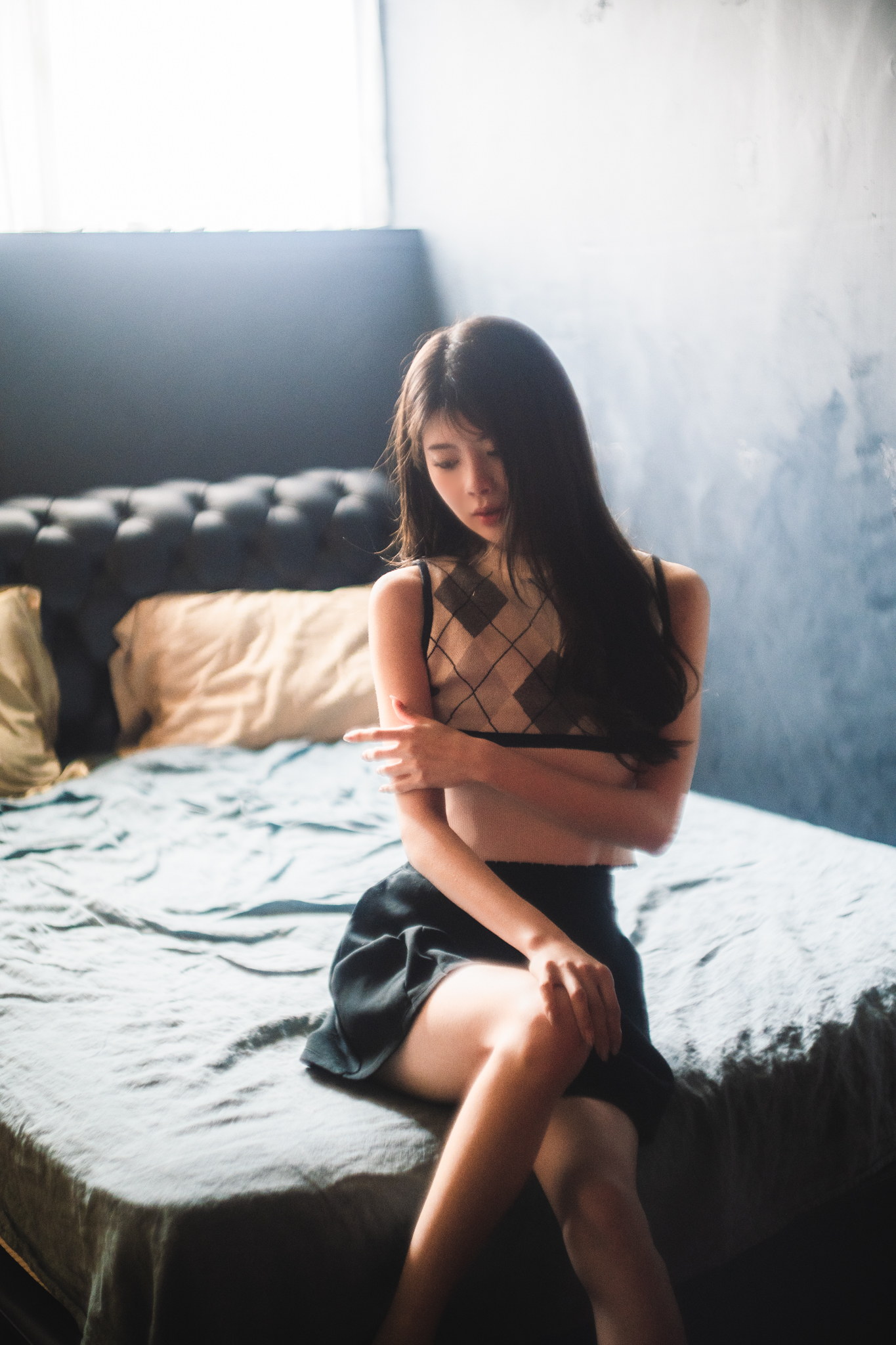 穿着黑色衣服的女人坐在床上。