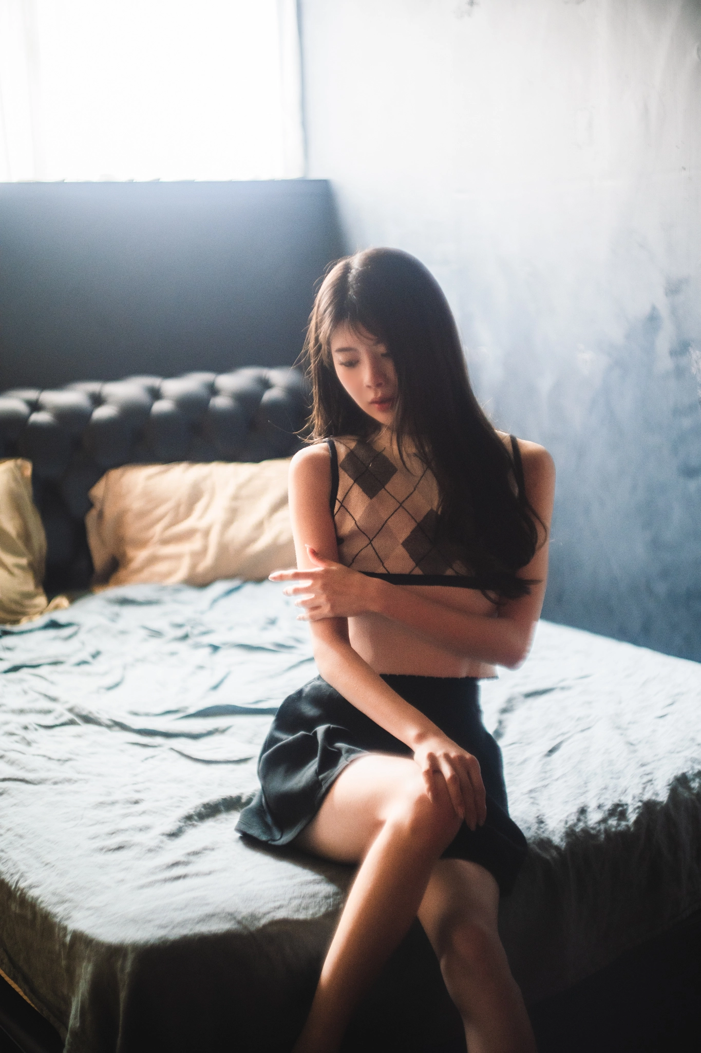 穿着黑色衣服的女人坐在床上。