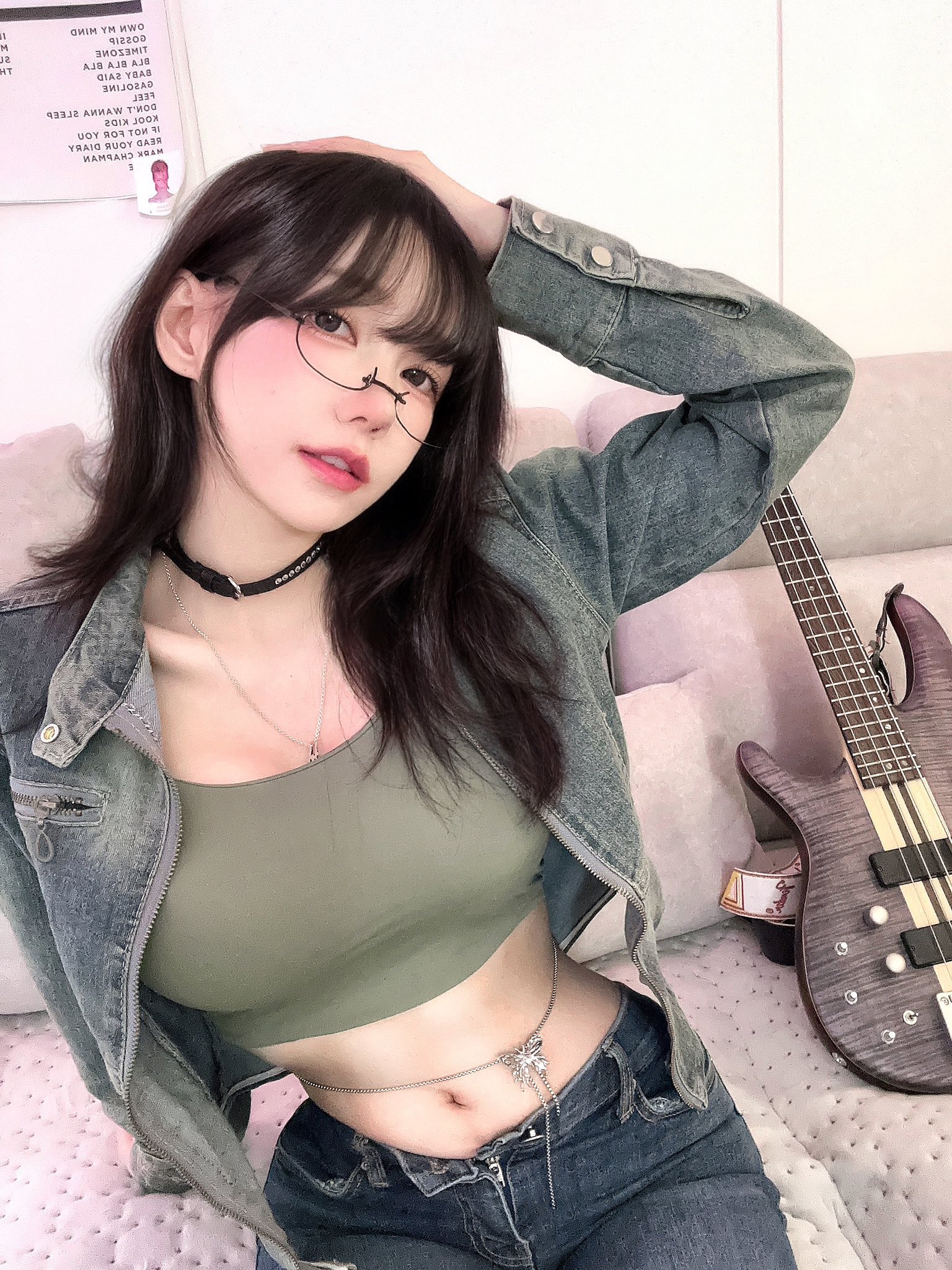 一位戴着眼镜和一件绿色衬衫的女人用吉他出戏。