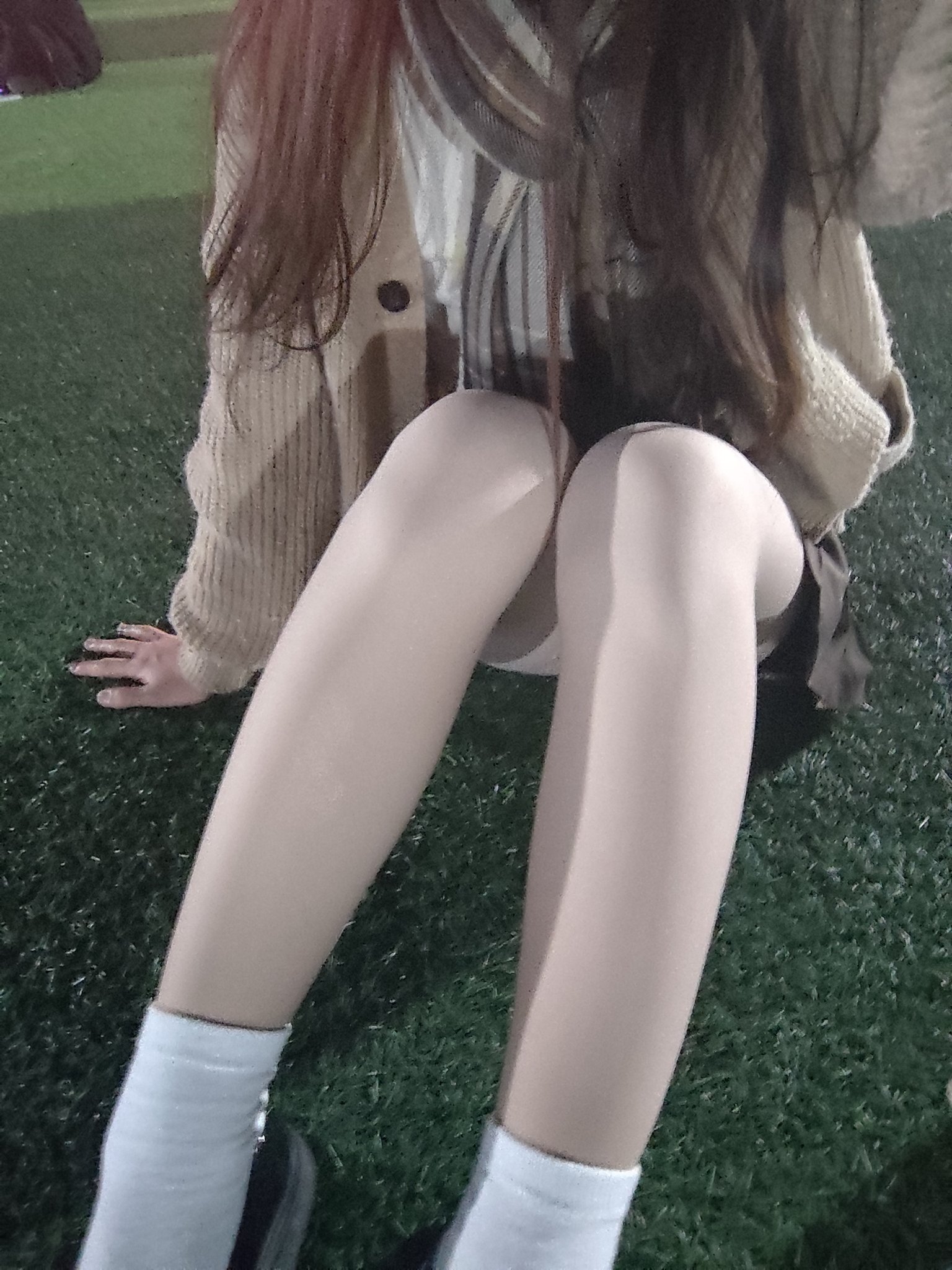 穿着棕色裙子和白色袜子的女人坐在蓝色的沙发上。