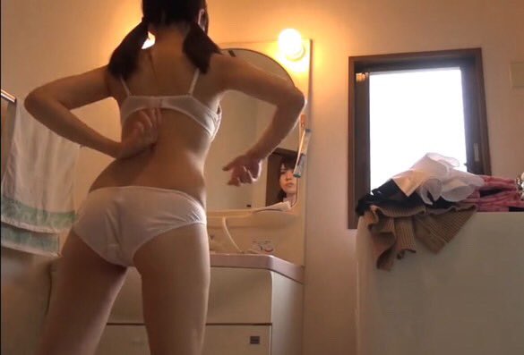 穿着白色衬衫的女人在镜子里看着自己。