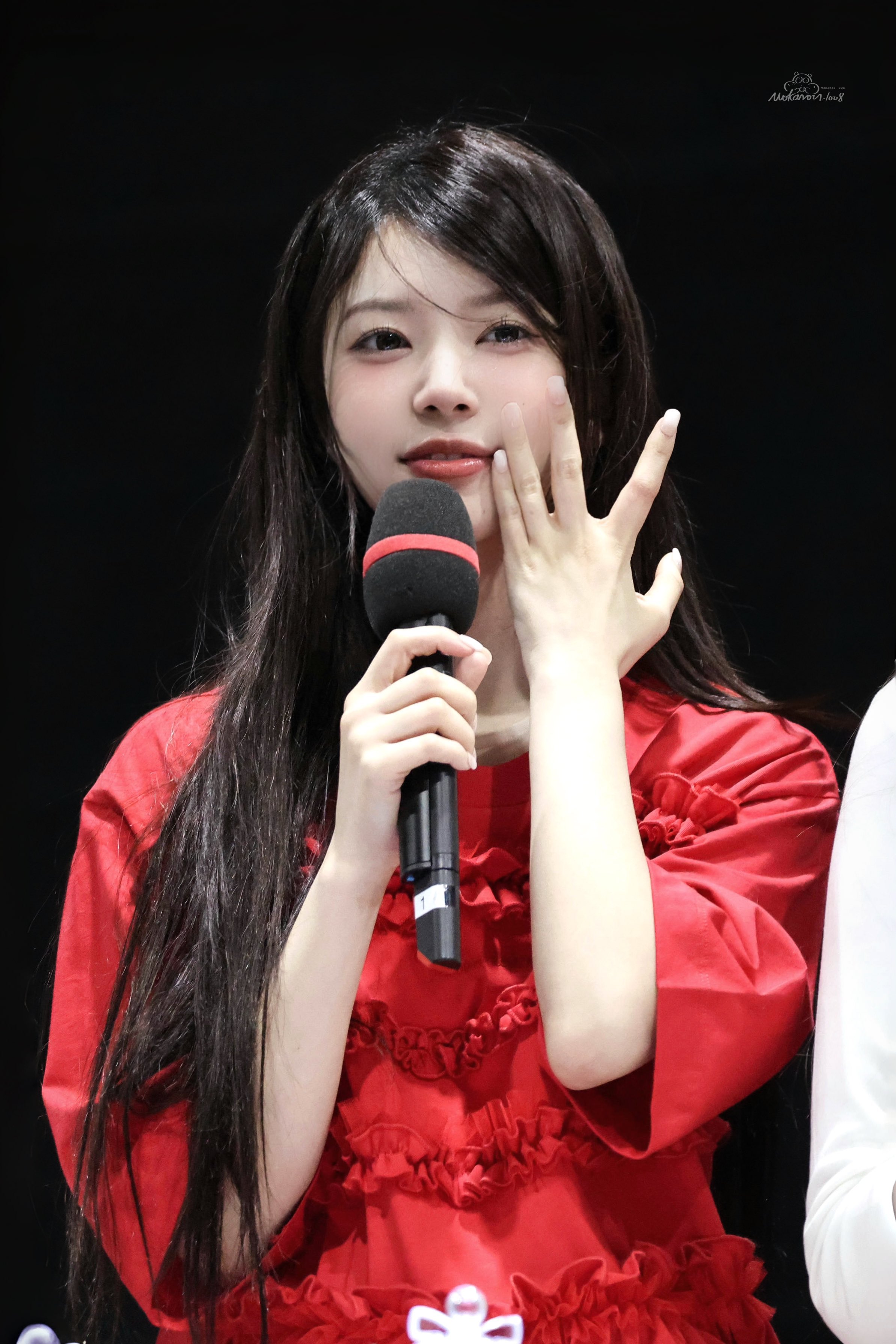 穿着红色衬衫的女人拿着麦克风。