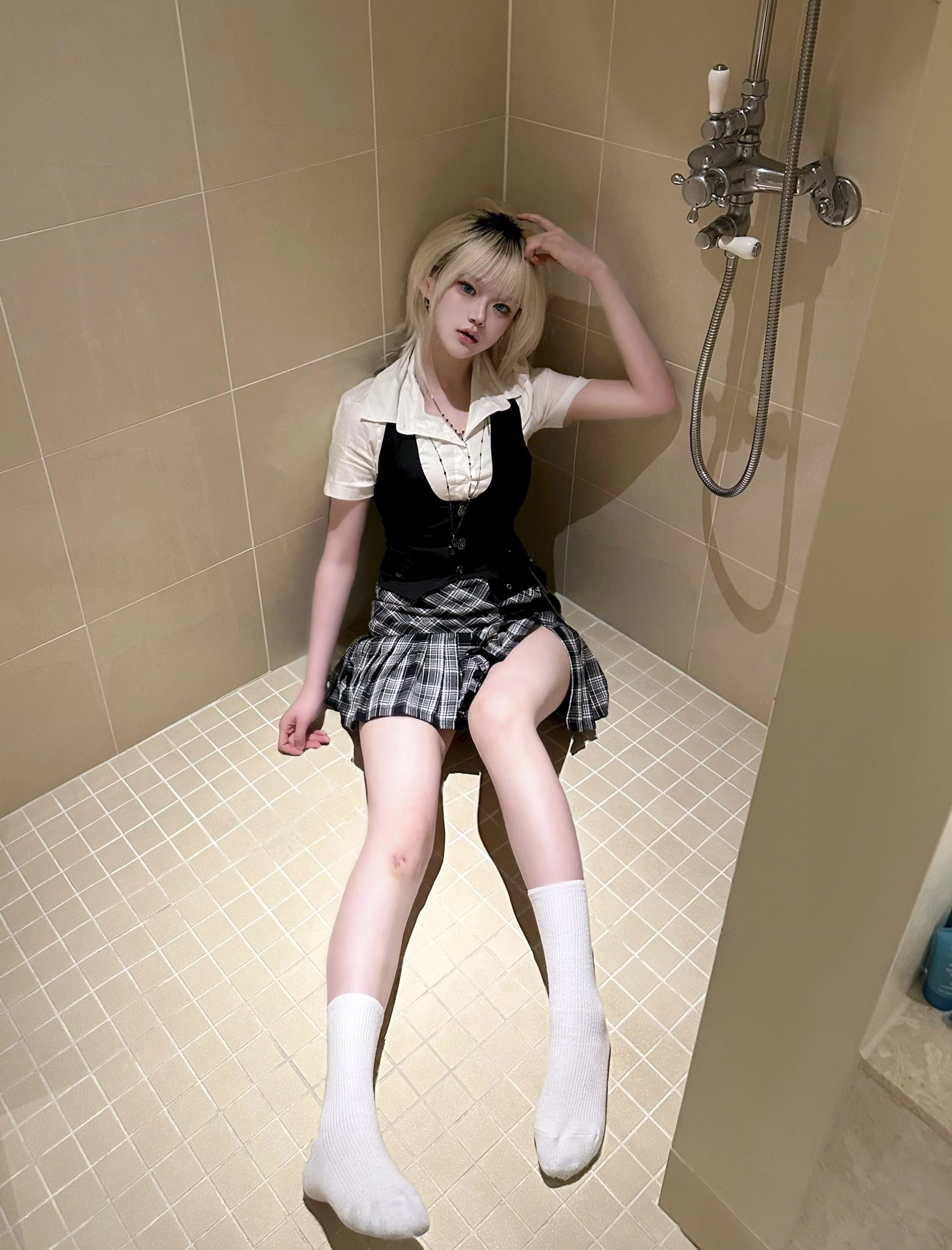 穿着黑白裙子的女人坐在浴室的地板上。