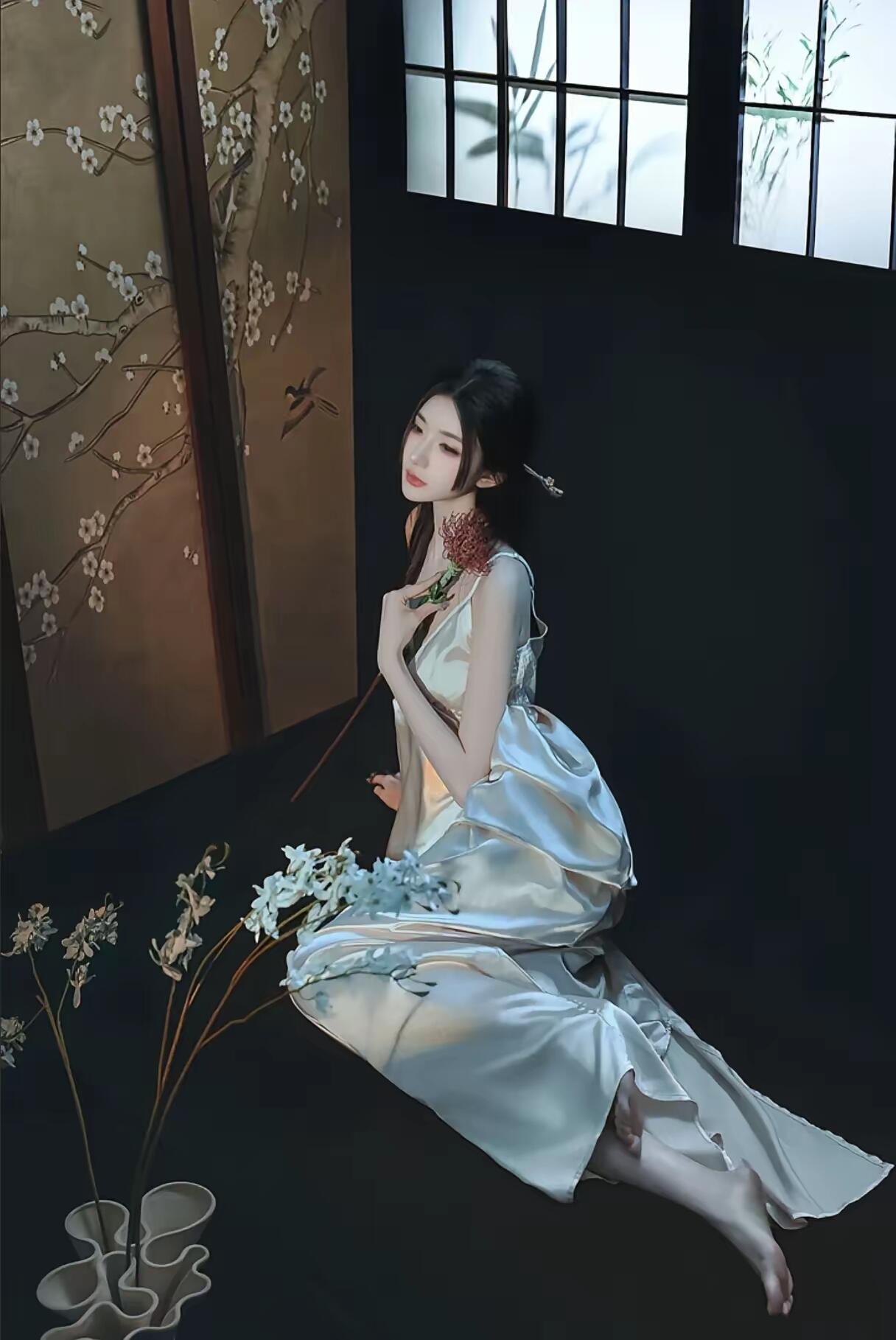 穿着白色衣服的女人抱着一朵花。