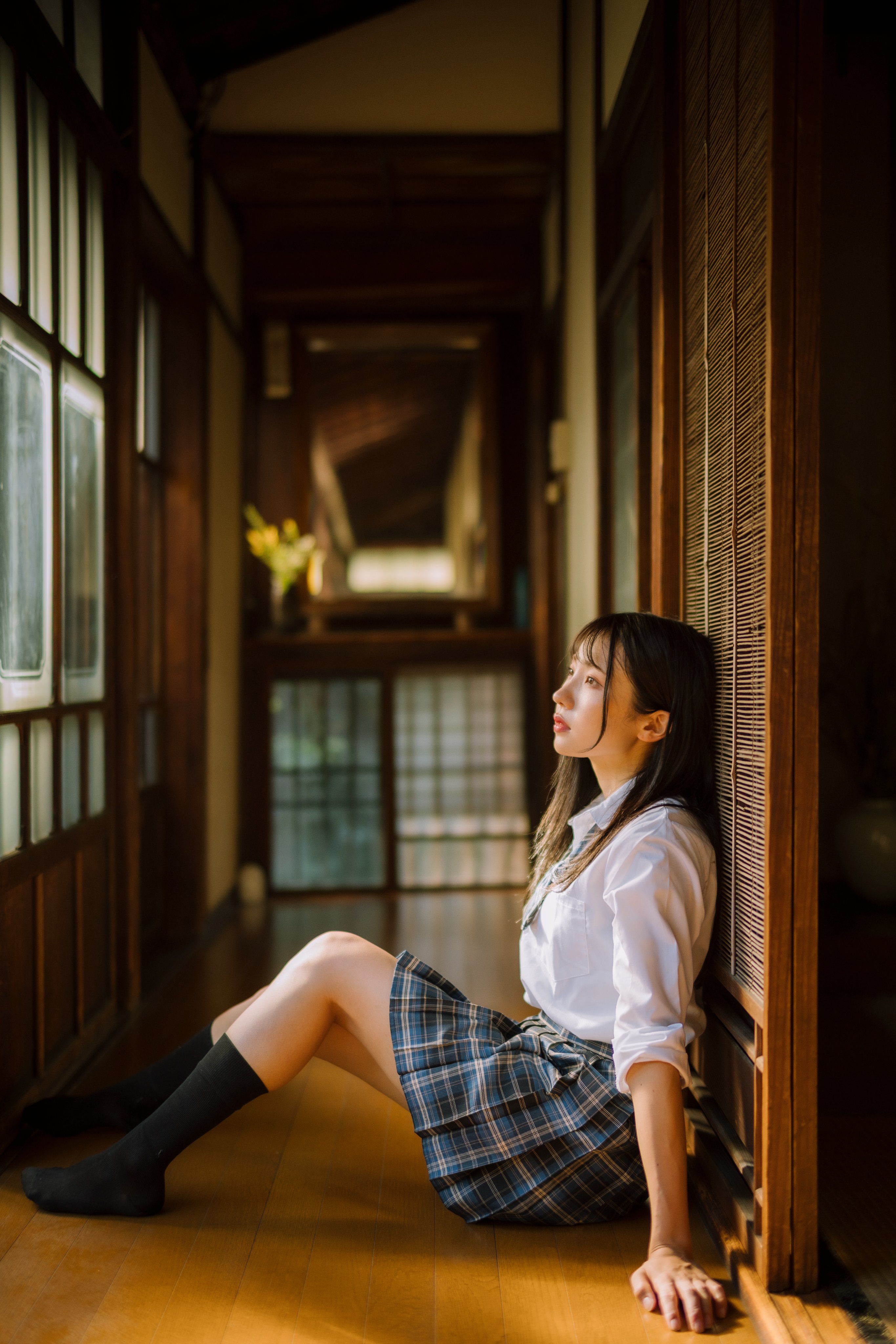 穿着白色衬衫和黑色衬衫的女人坐在窗户上。