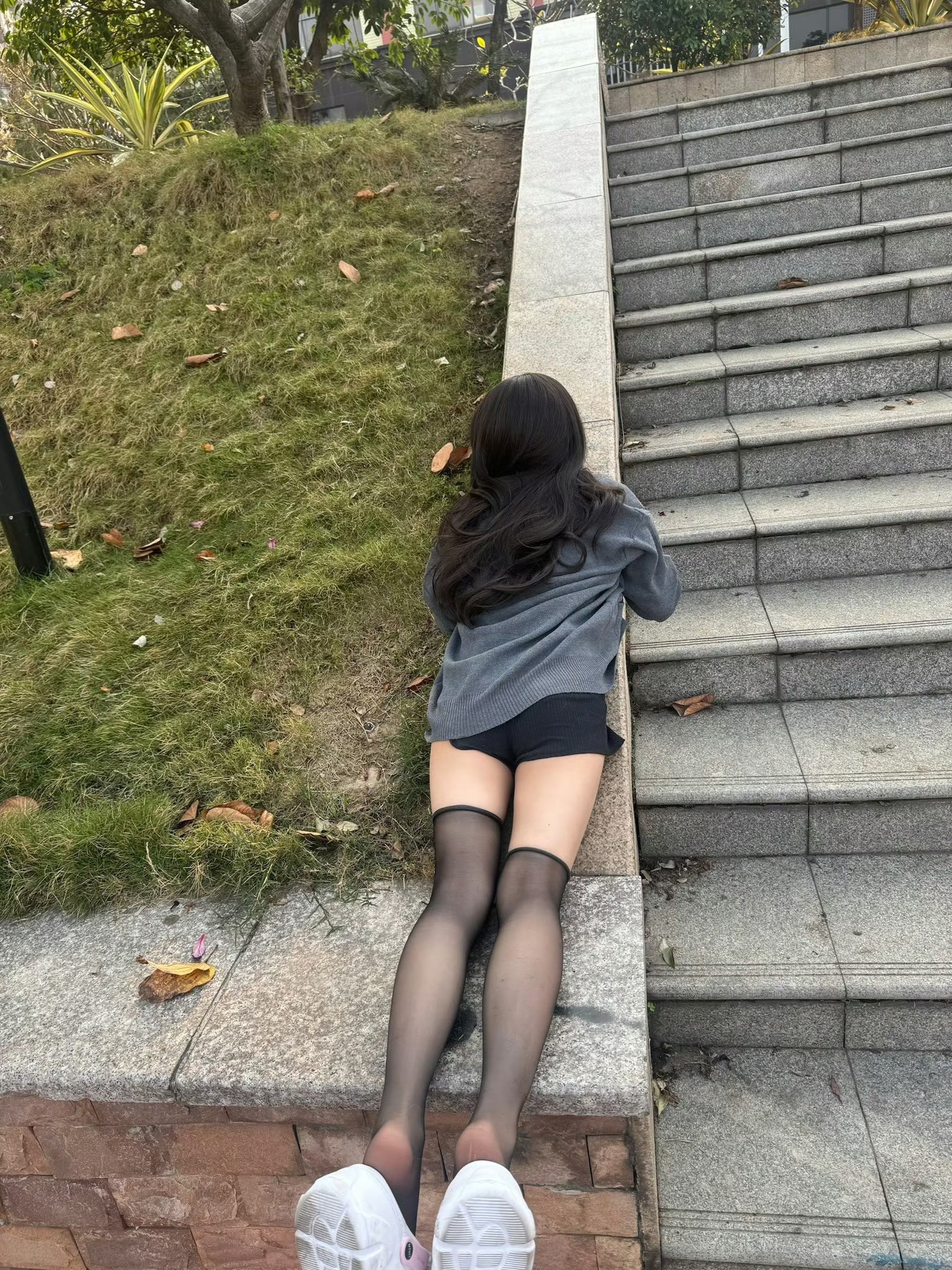 穿着黑色衬衫和灰色衬衫的女人躺在地上。