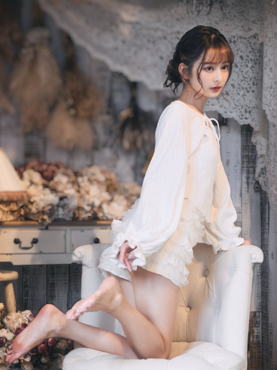 穿着白色衣服的女人坐在椅子上。