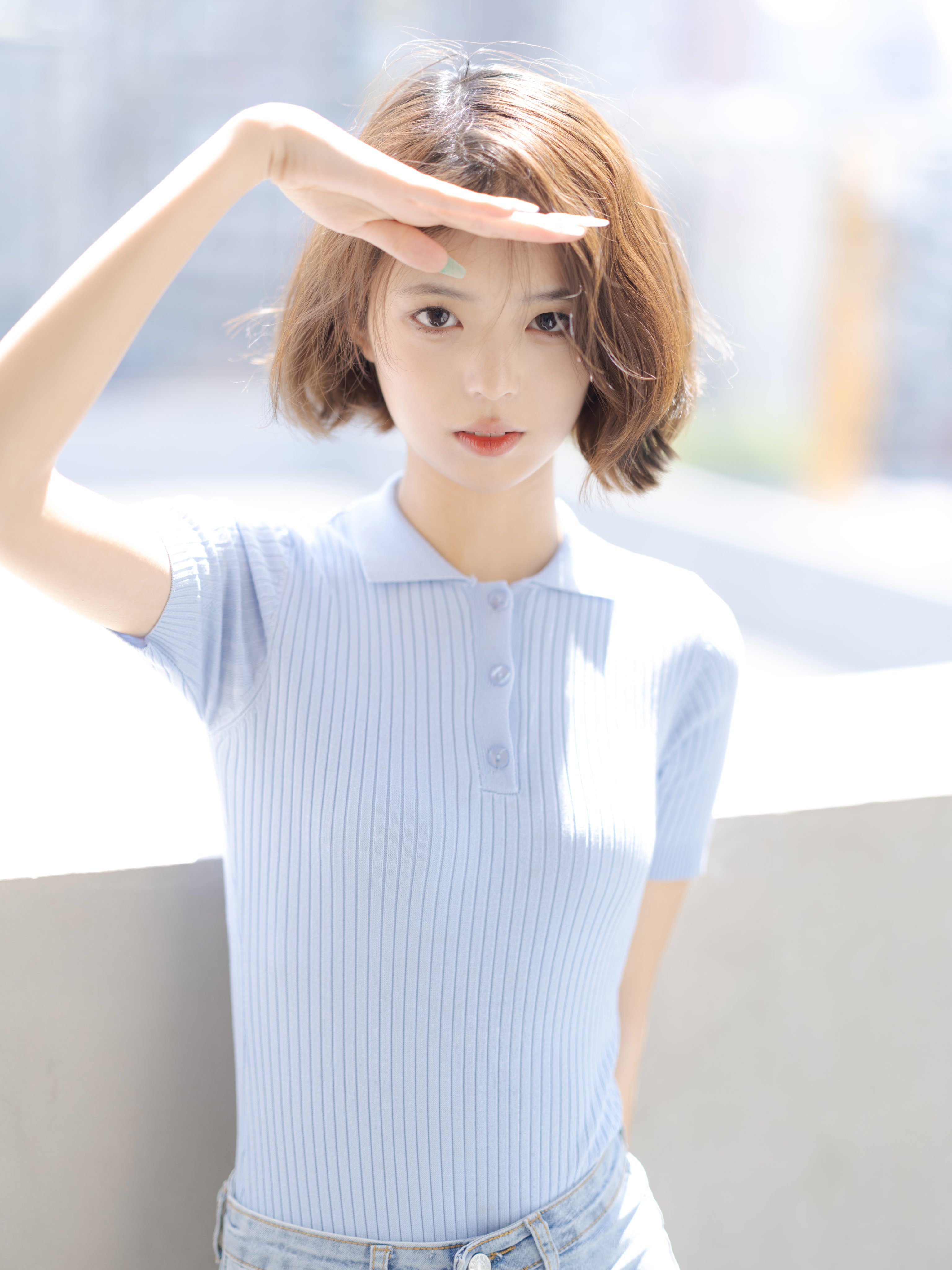 女人穿着蓝色衬衫,举起手来。