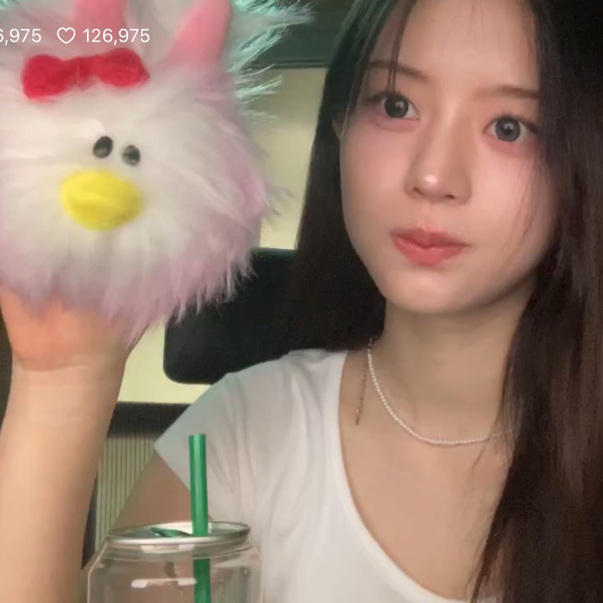 女人抱着一只粉红色的动物。