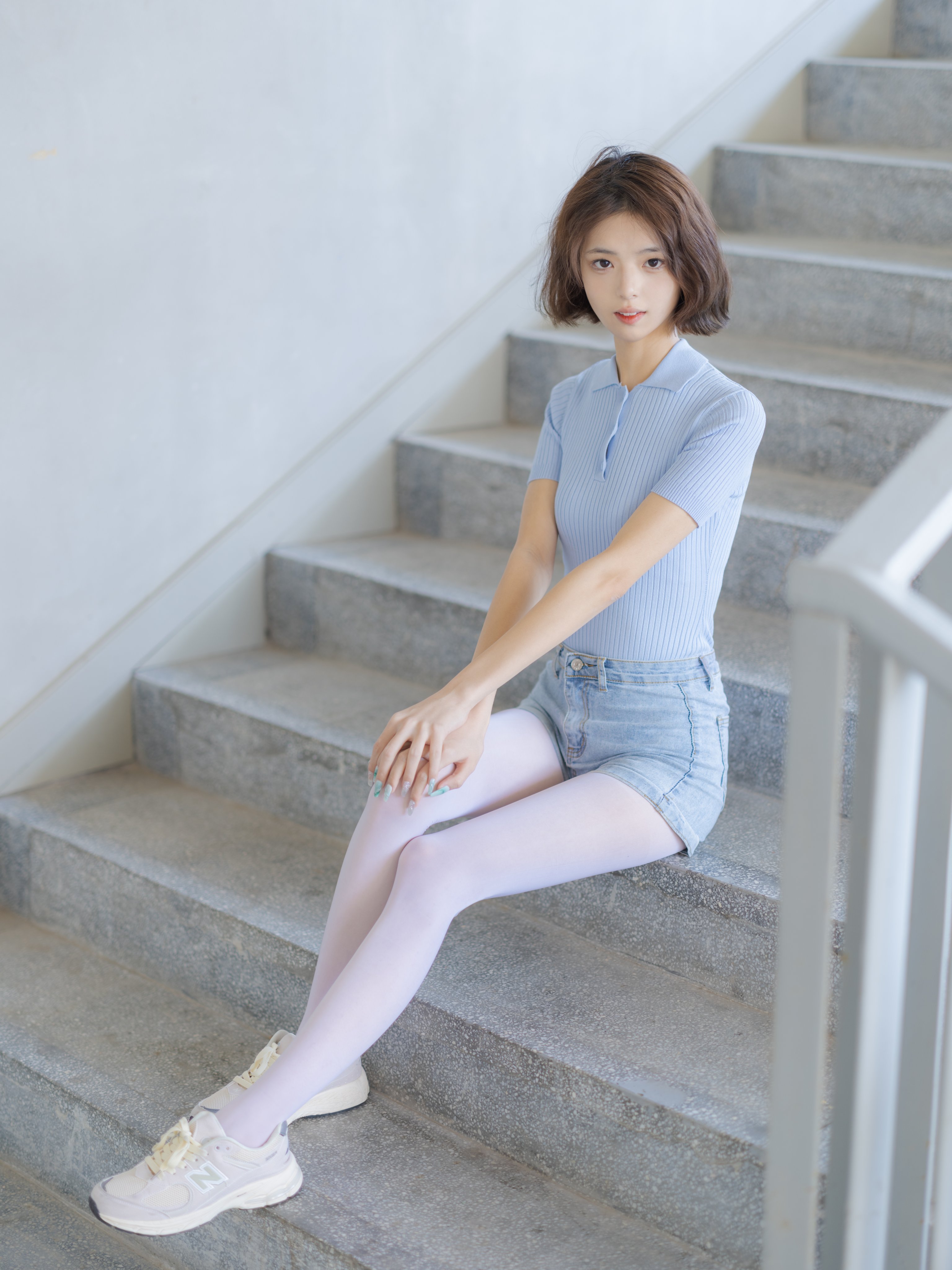 女人穿着蓝色衬衫,举起手来。