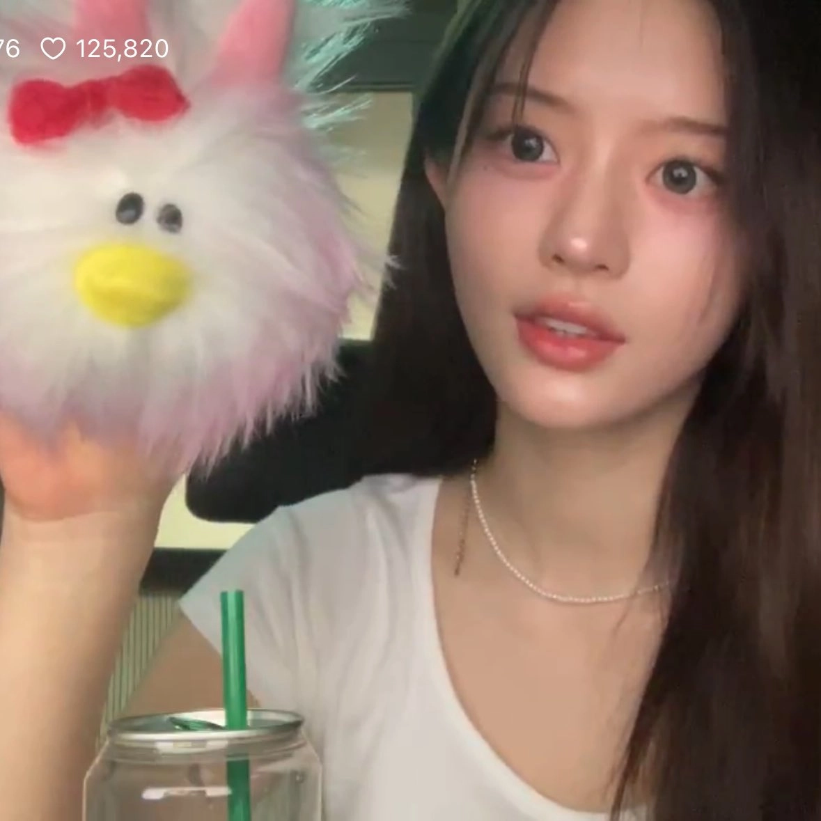 女人抱着一只粉红色的动物。