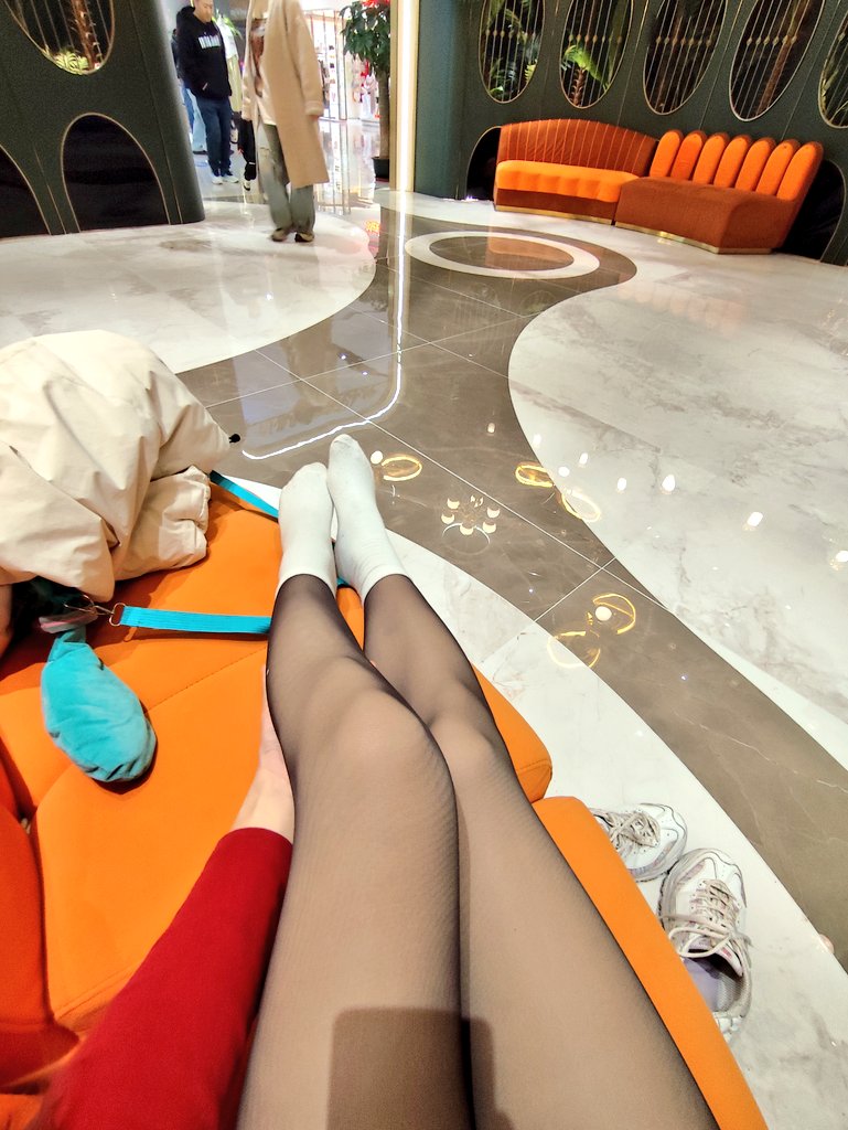 穿着粉红色夹克和蓝色短裤的女人正在镜子里拍照。