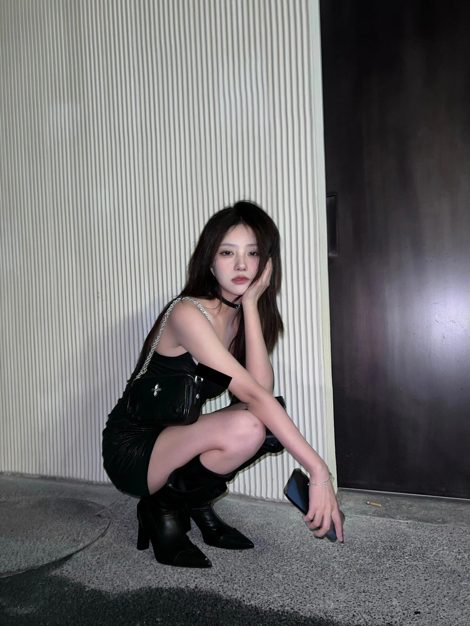 一位穿着黑色衣服的女人站在一堵壁壁上,上面装着涂鸦。