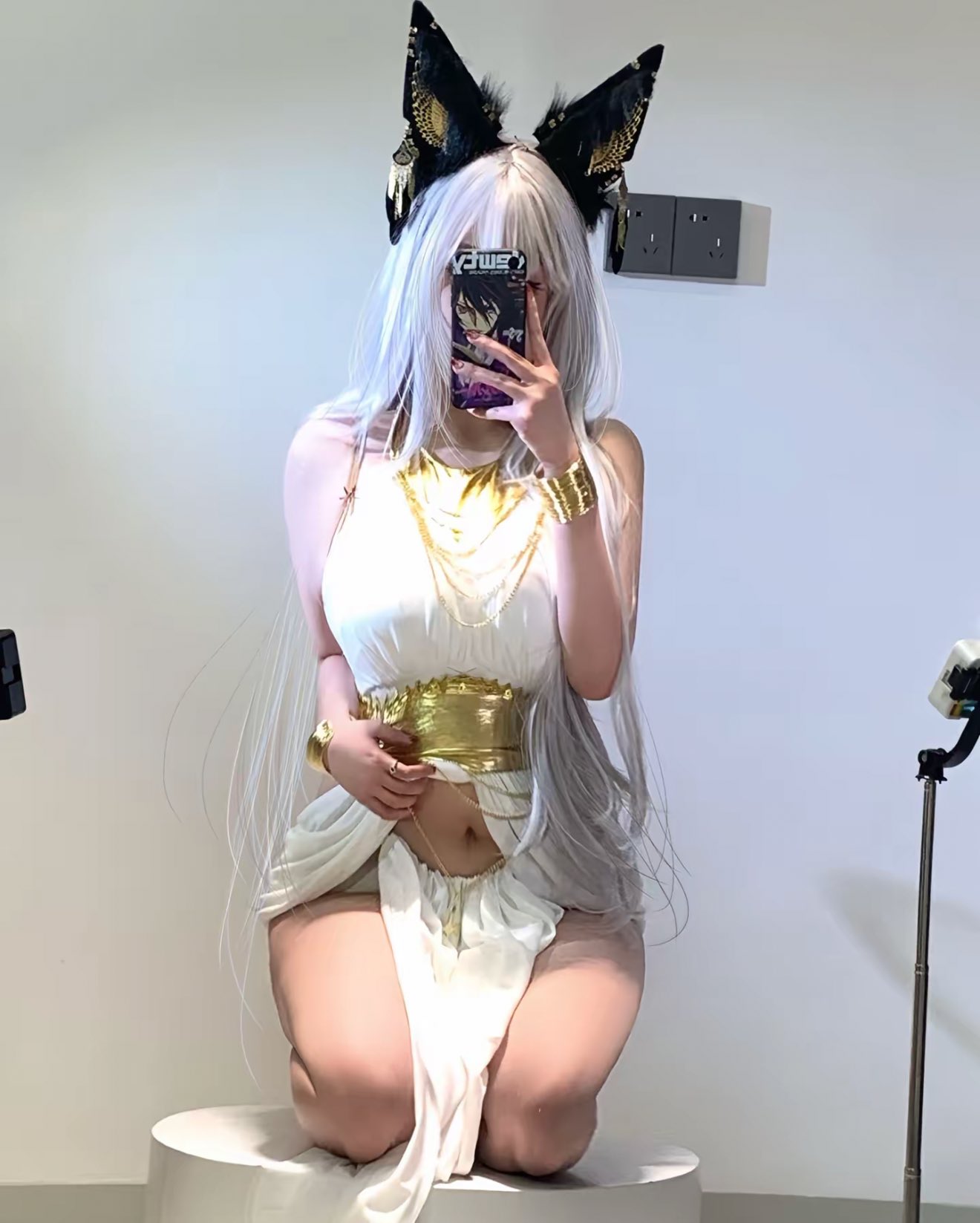 一位穿着白色裙子和金色头带的女人拍了一张自拍。