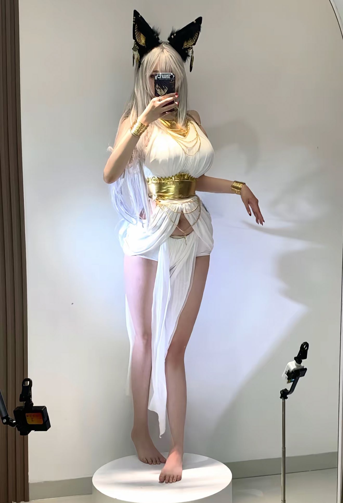 一位穿着白色裙子和金色头带的女人拍了一张自拍。