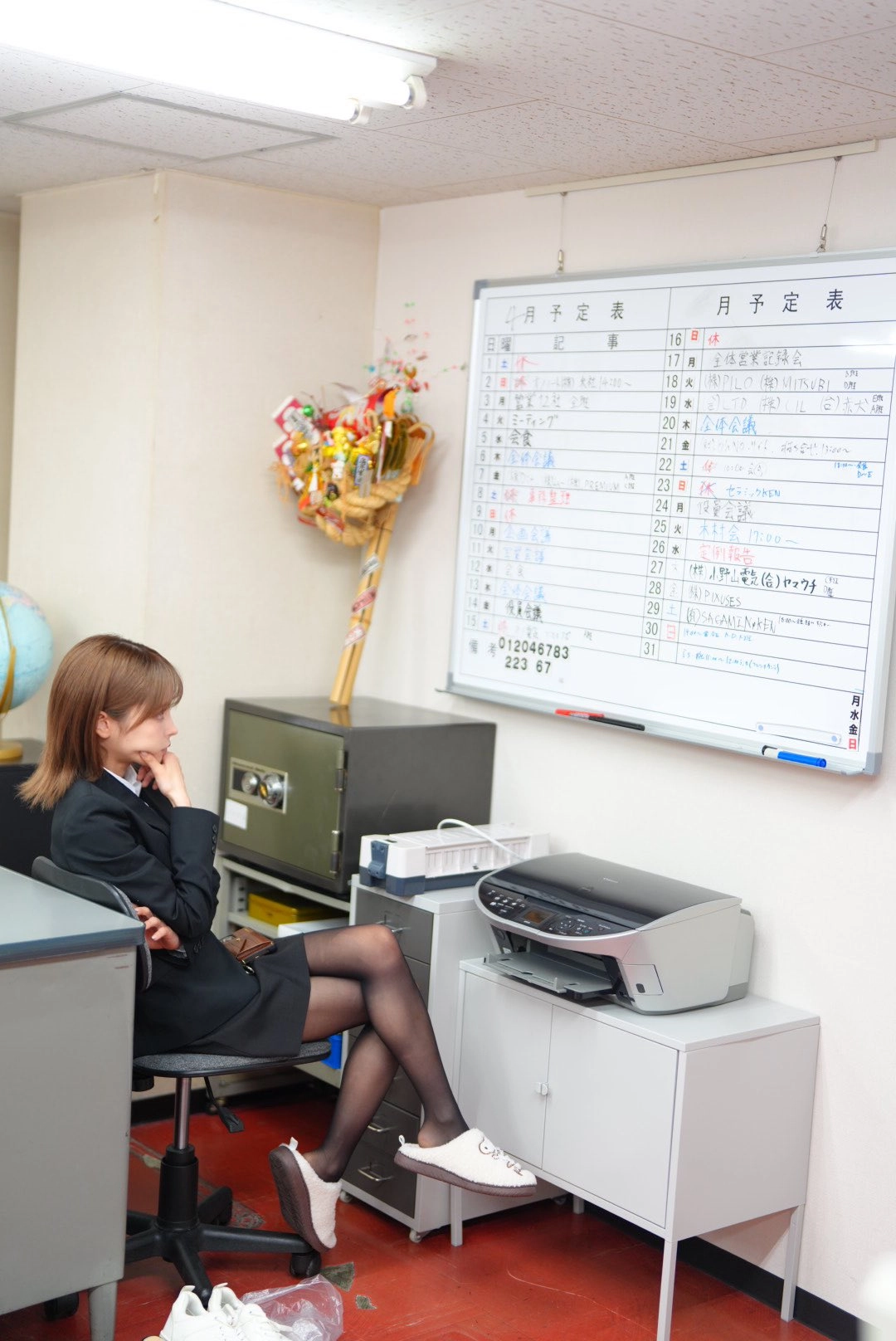 一位穿着黑色服装的女人坐在一张桌子上,在她面前有一台电脑显示器。