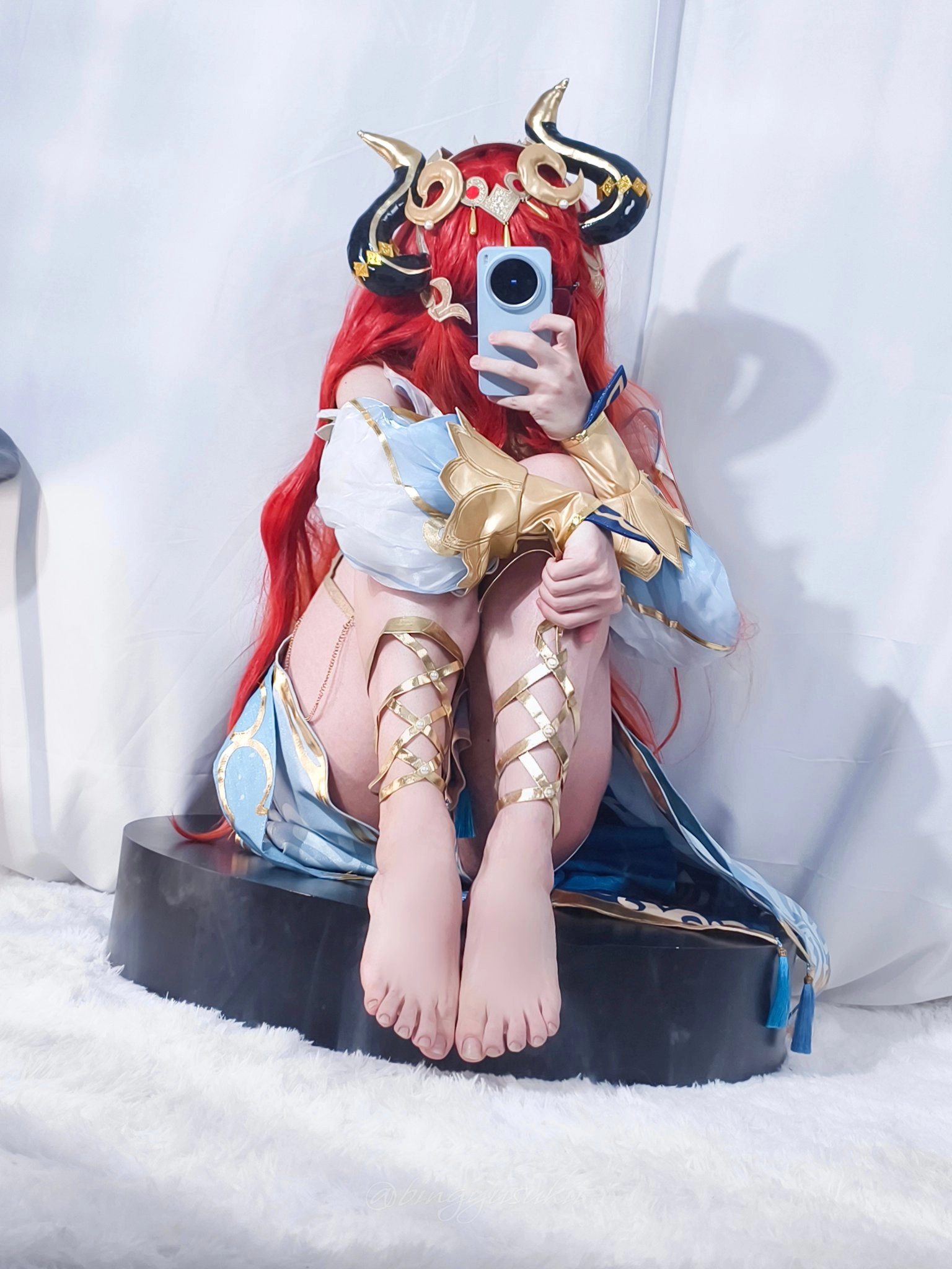 一位穿着蓝色和金色的女士用手机拍了一张自拍。