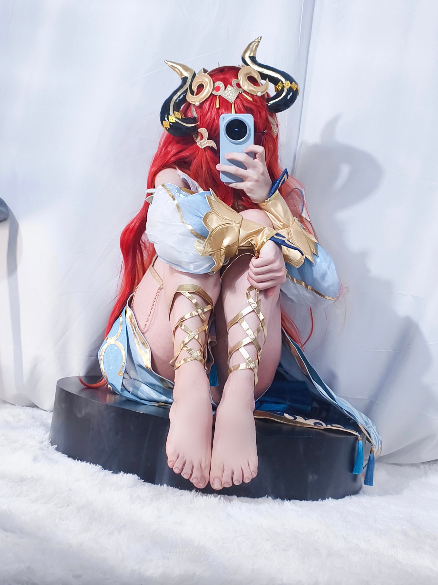 一位穿着蓝色和金色的女士用手机拍了一张自拍。