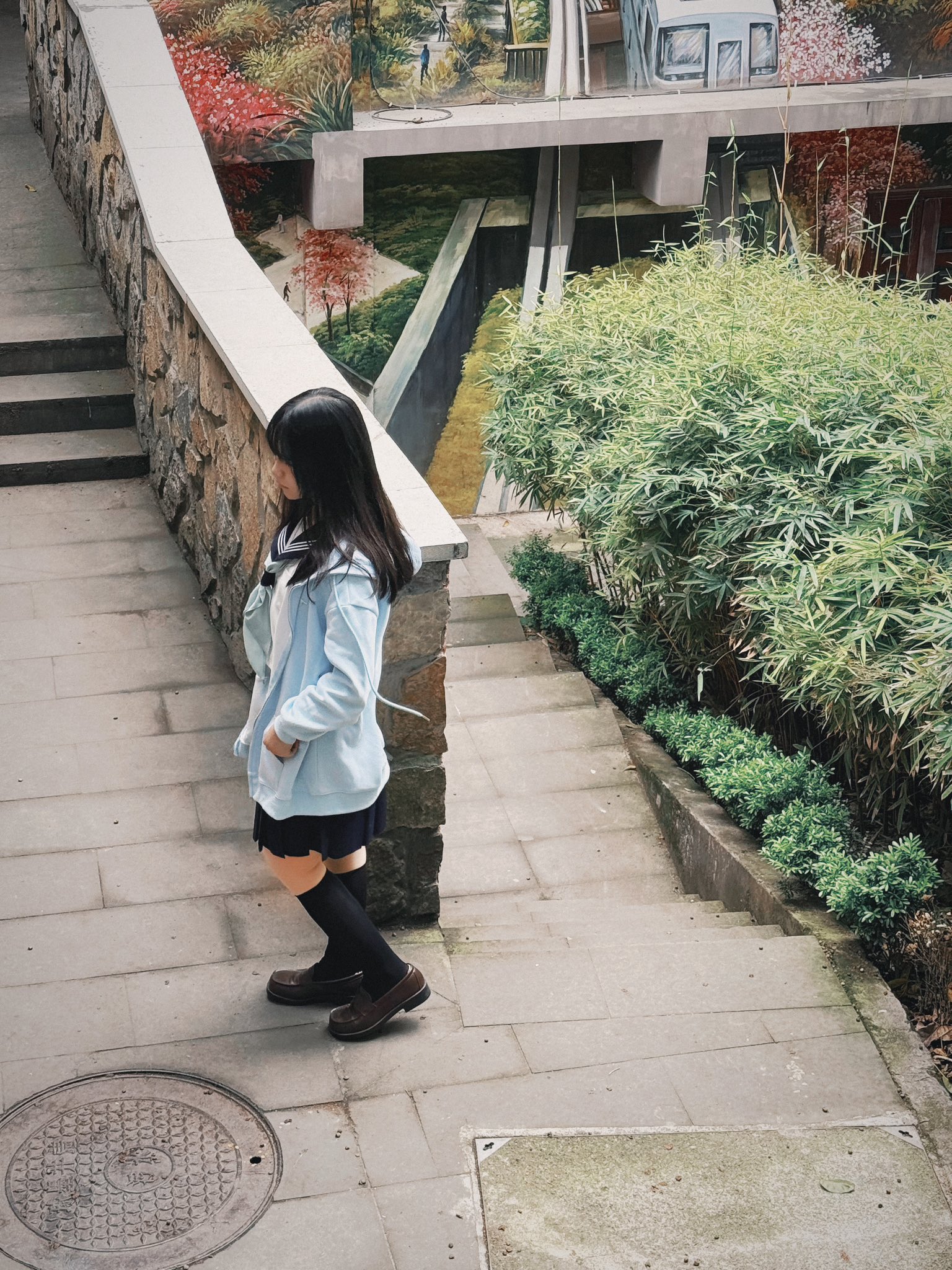 一位穿着蓝色夹克和黑色鞋子的女人走上了一条走廊。