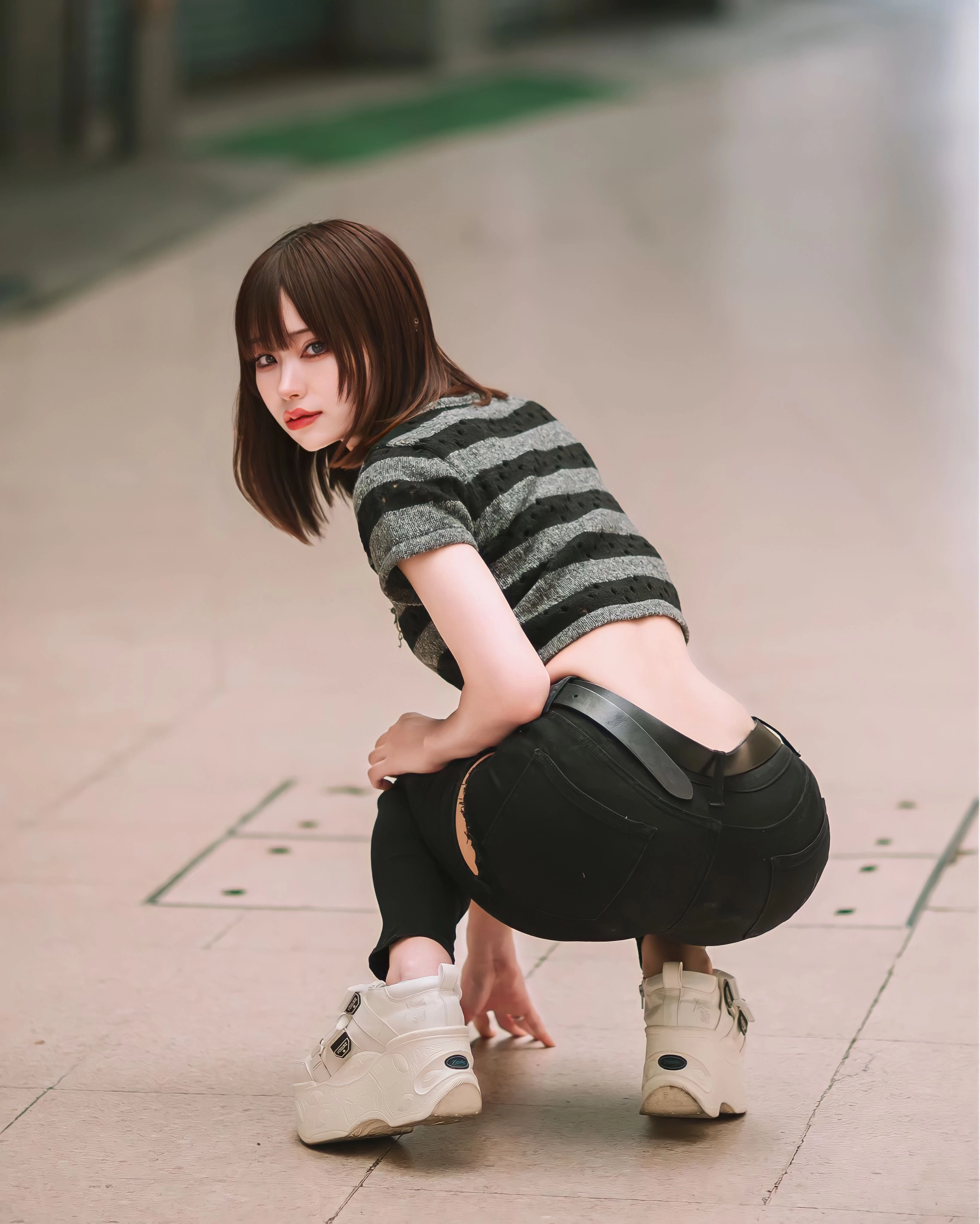 穿着黑色和白色带衬衫和黑色裤子的女人跪在地上。