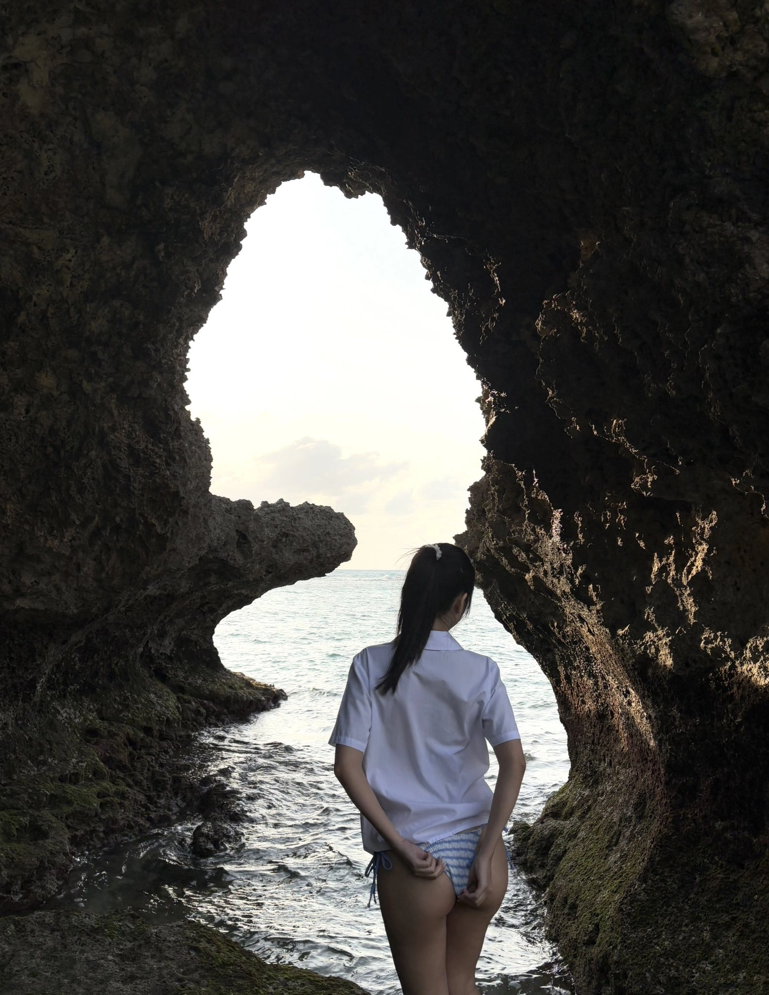 女人站在洞穴里。