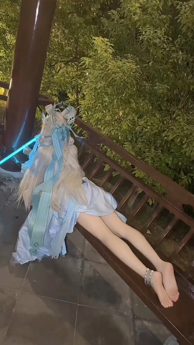 穿着蓝色裙子的女人坐在一个凳子上。