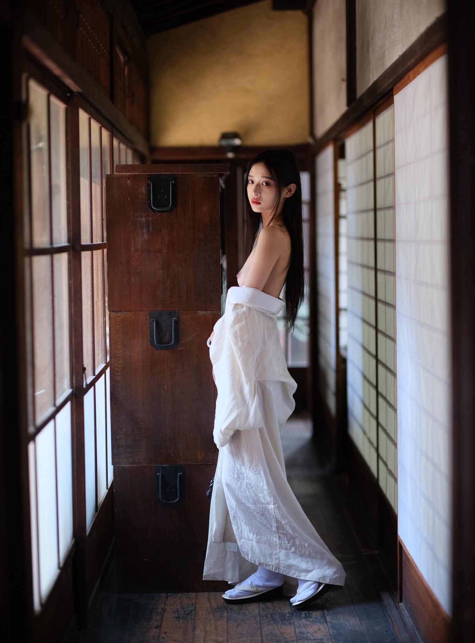 穿着白色衣服的女人站在走廊上。