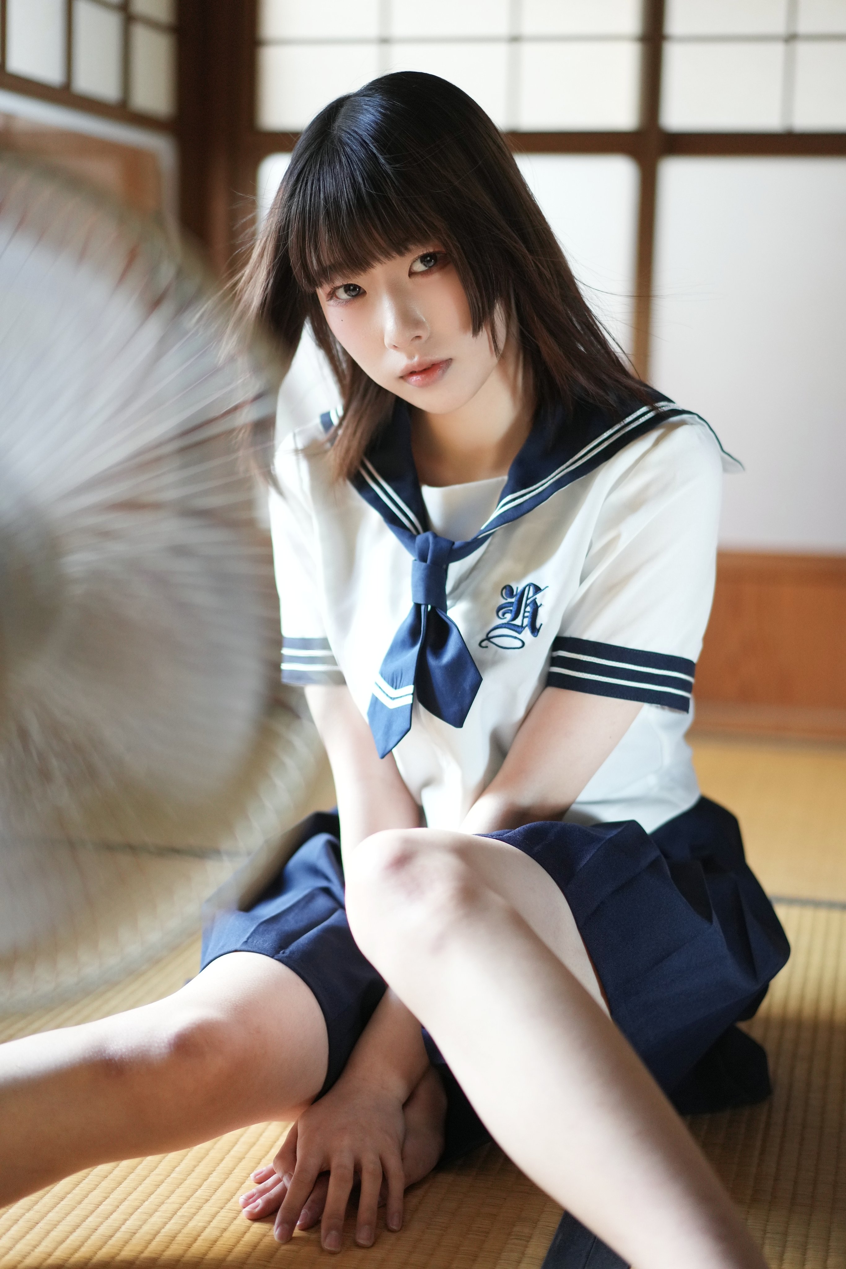 穿着水手制服的女人坐在地板上。