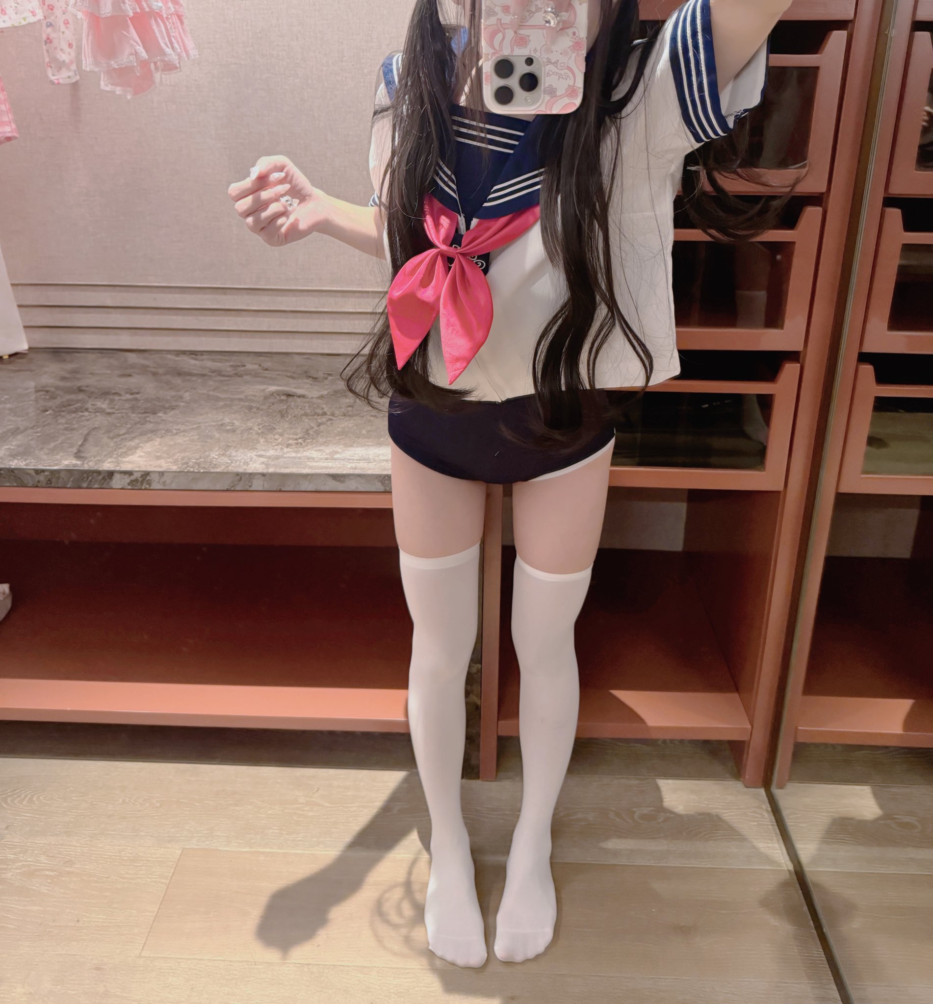 穿着水手服的女孩,拿着手机。