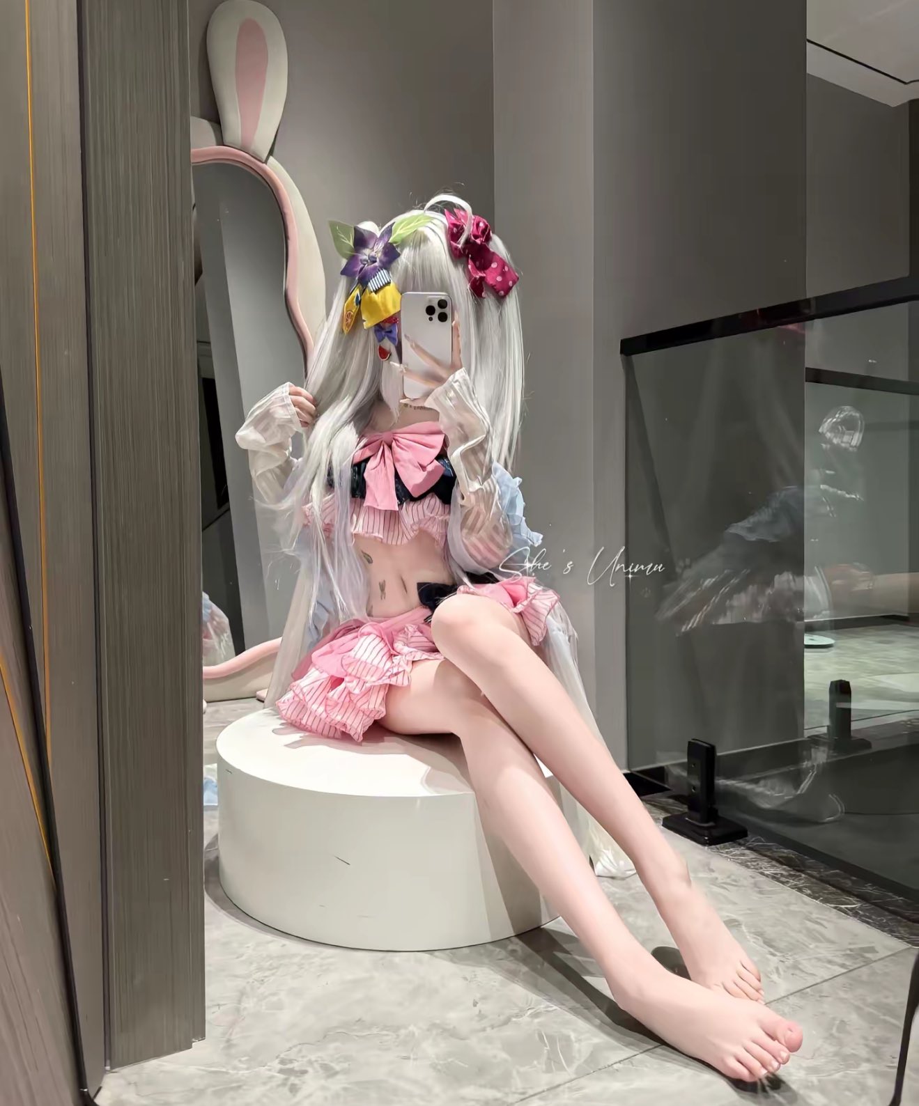 穿着粉红色的裙子和白色的头发的女人拍了一张自拍。