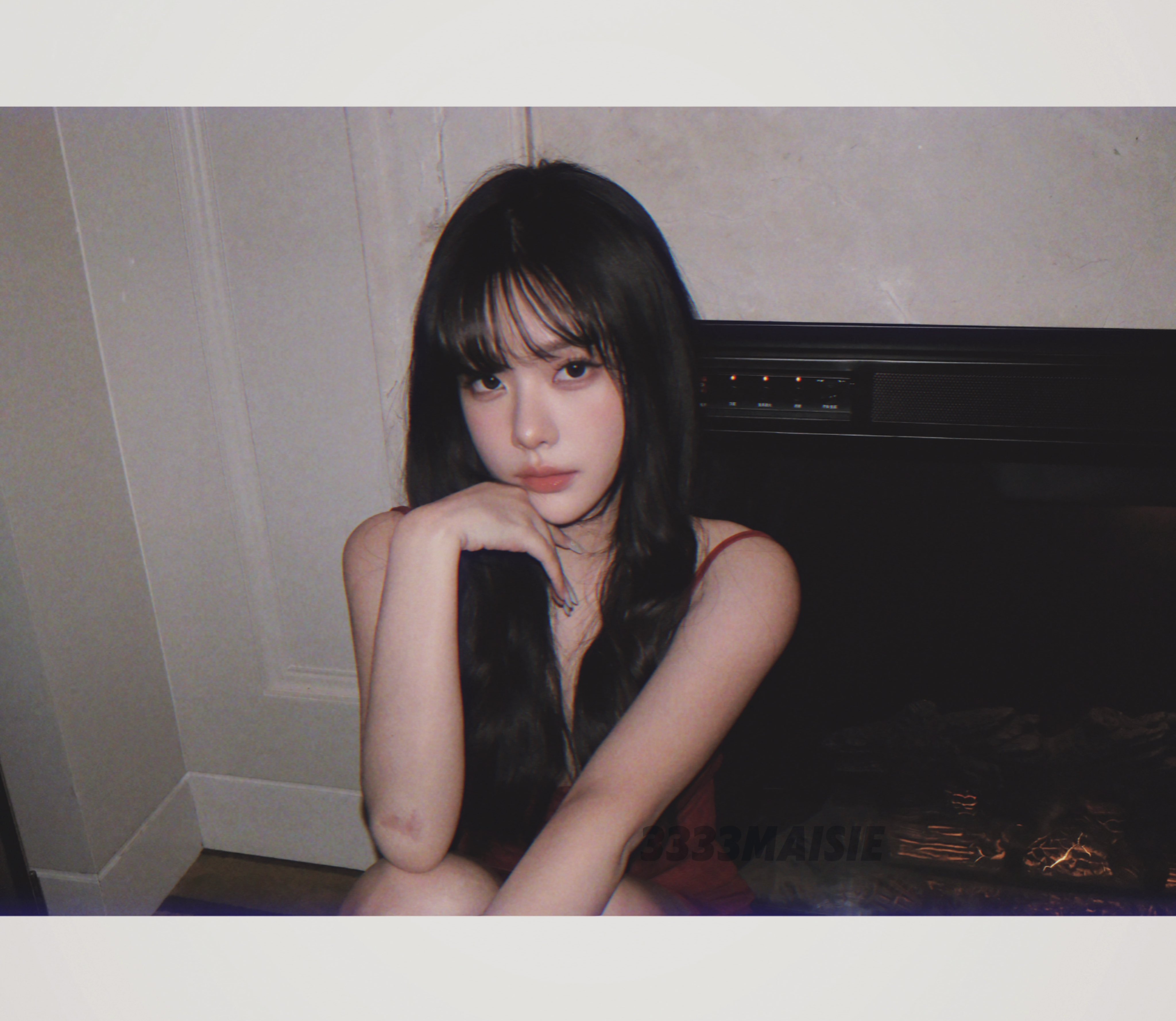 长头发和红色裙子的女人坐在炉子前。