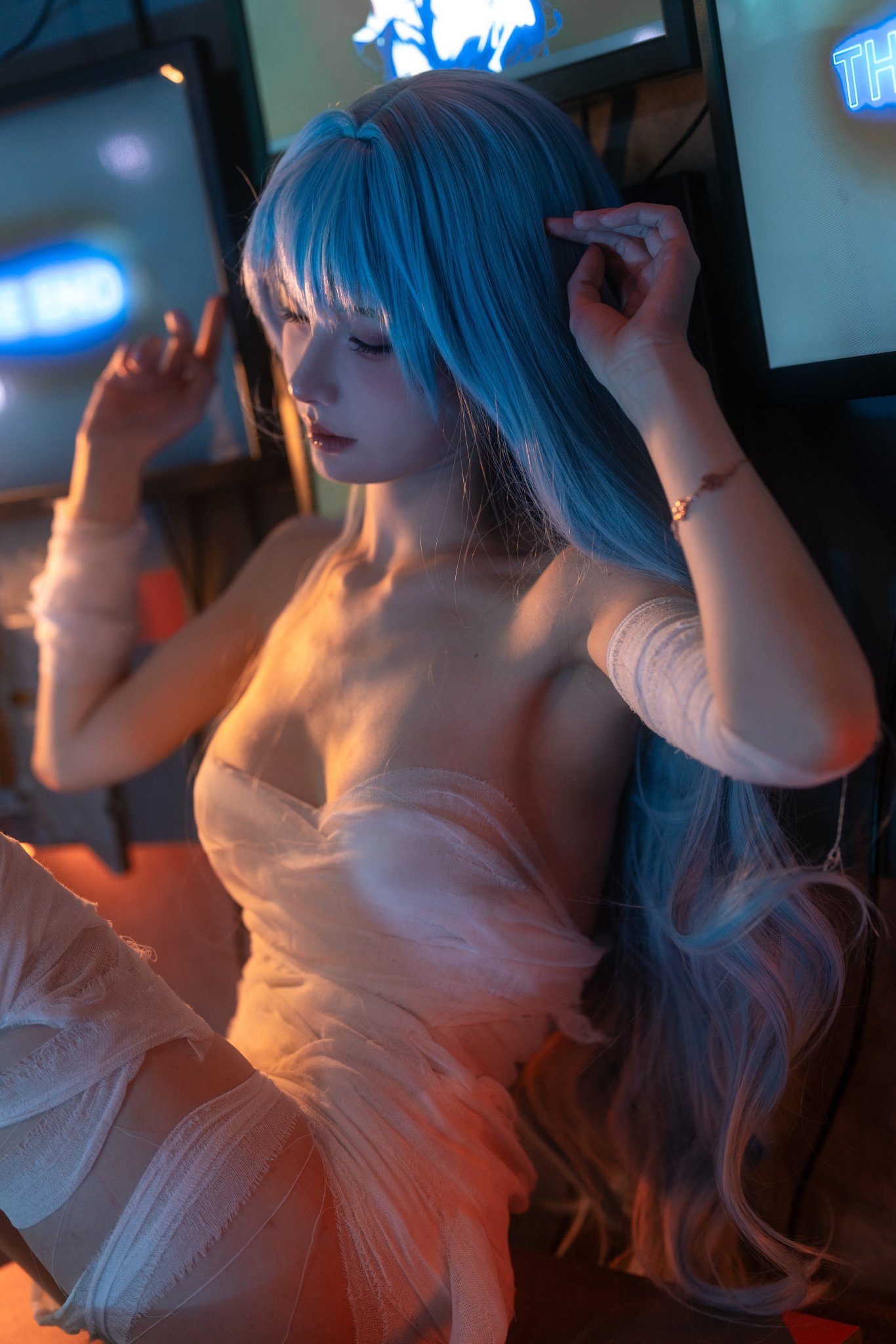 一位蓝头发和白色裙子的女人坐在视频游戏机前面。