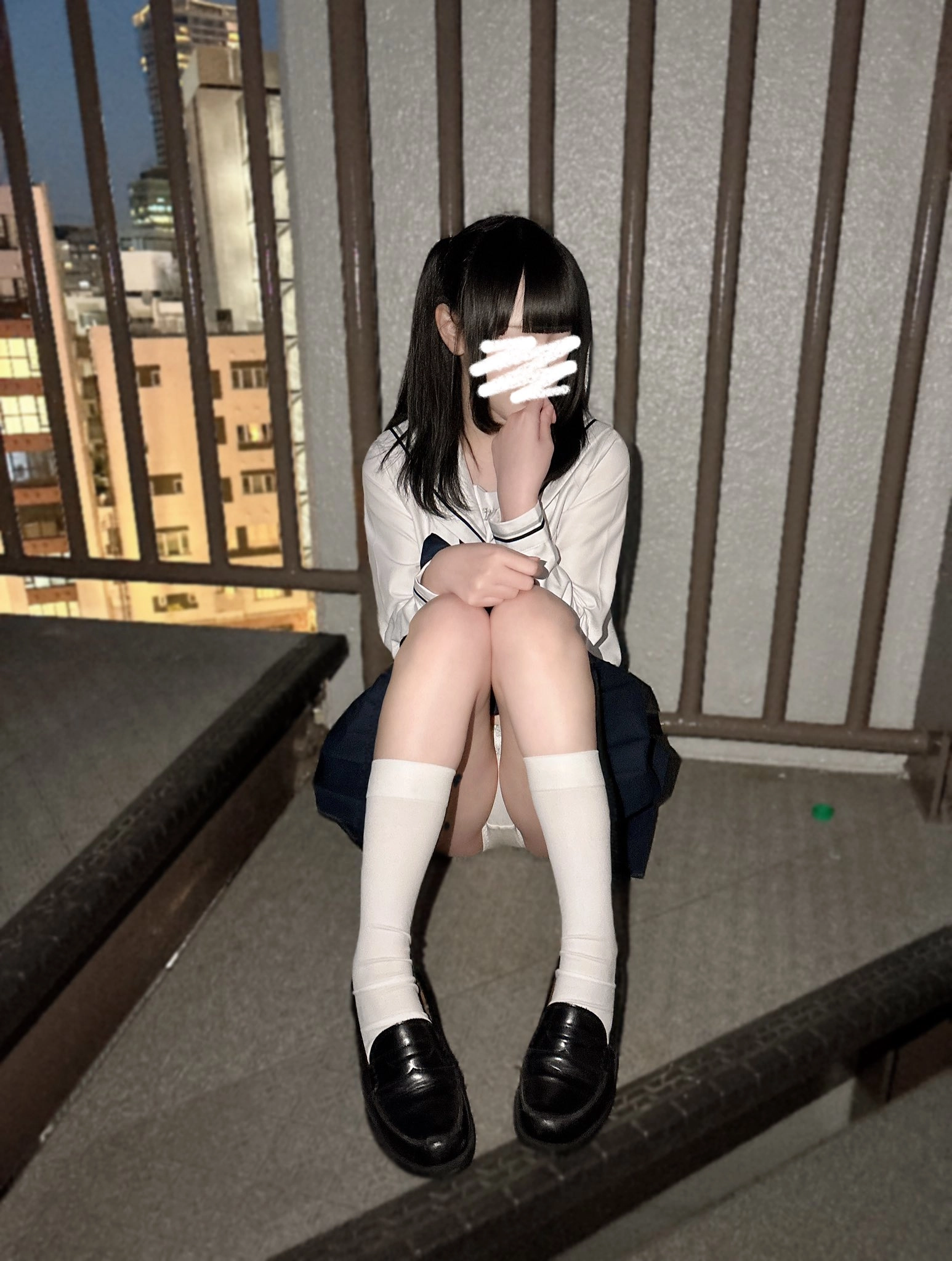 穿着白色衬衫和蓝色裙子的女孩坐在楼梯上。