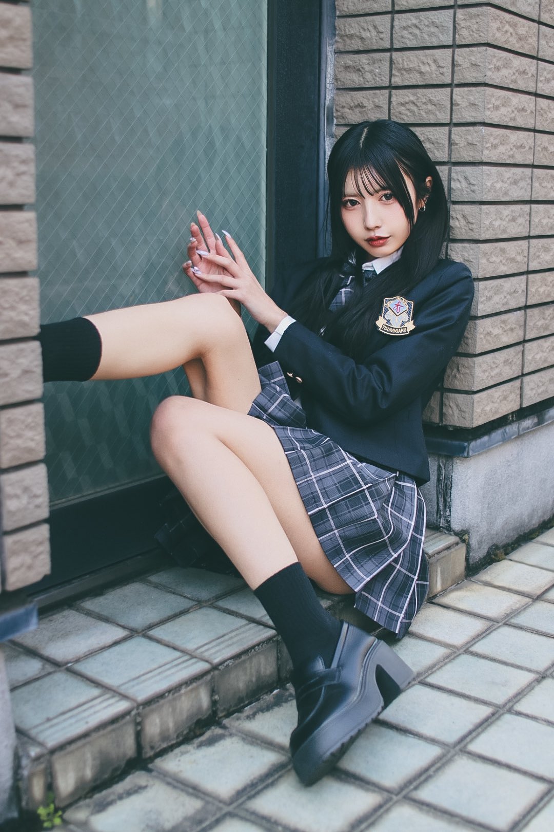 穿着一件黑色夹克和一件的裙子的女孩为一张照片。