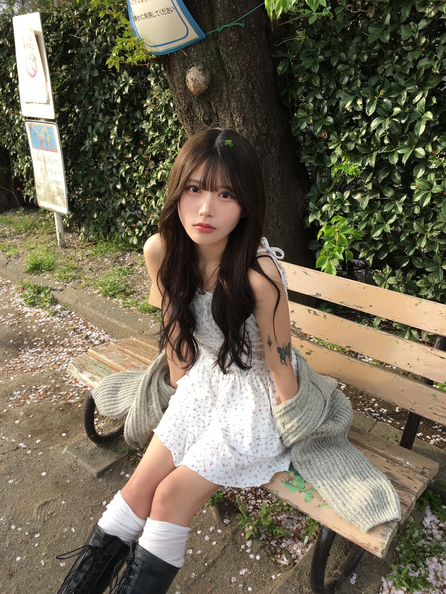 穿着白色裙子的女人坐在一个凳子上。