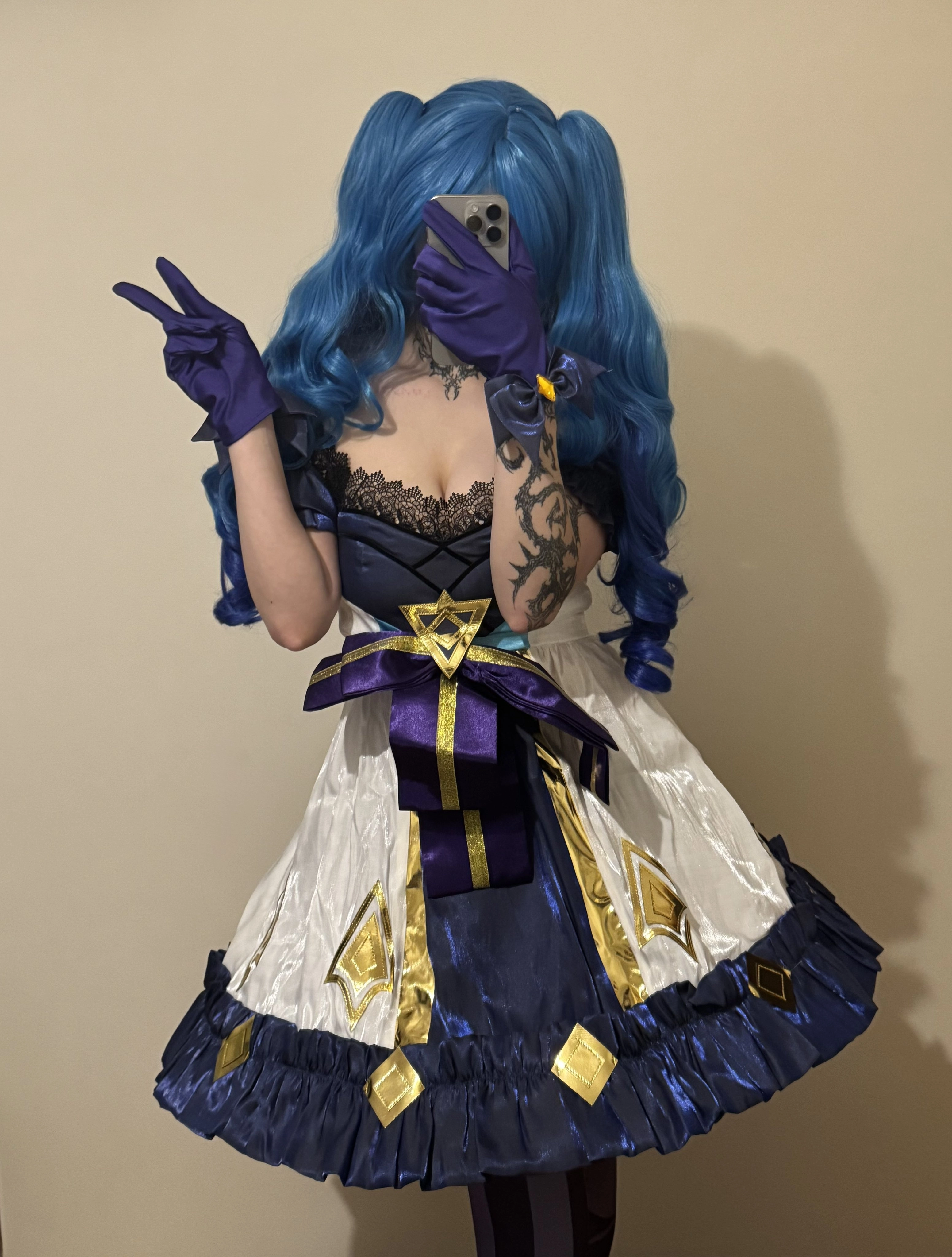 一位穿着蓝色裙子和紫色手套的女人拿着手机。