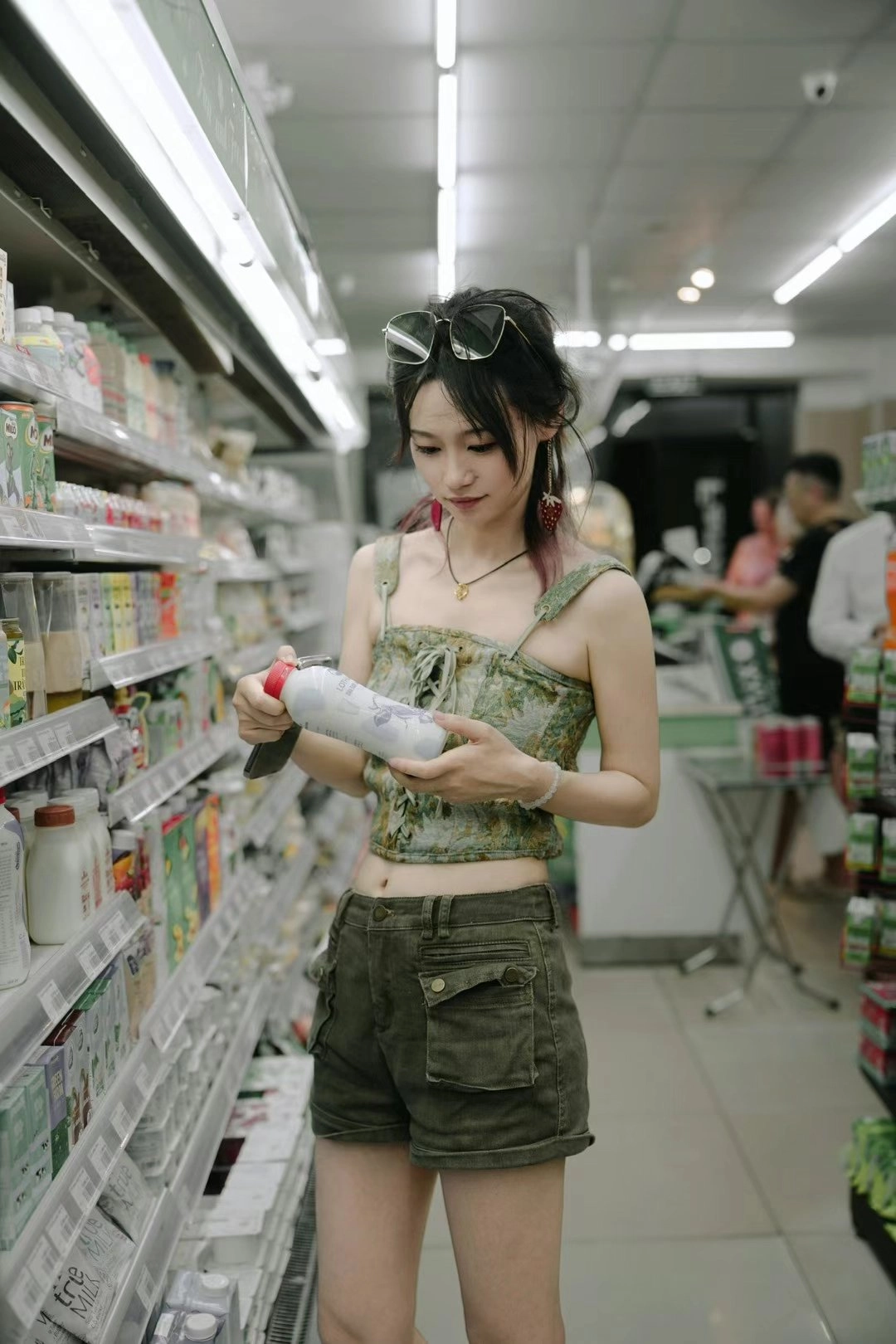 女人在一个杂货店里拿着一瓶奶油。