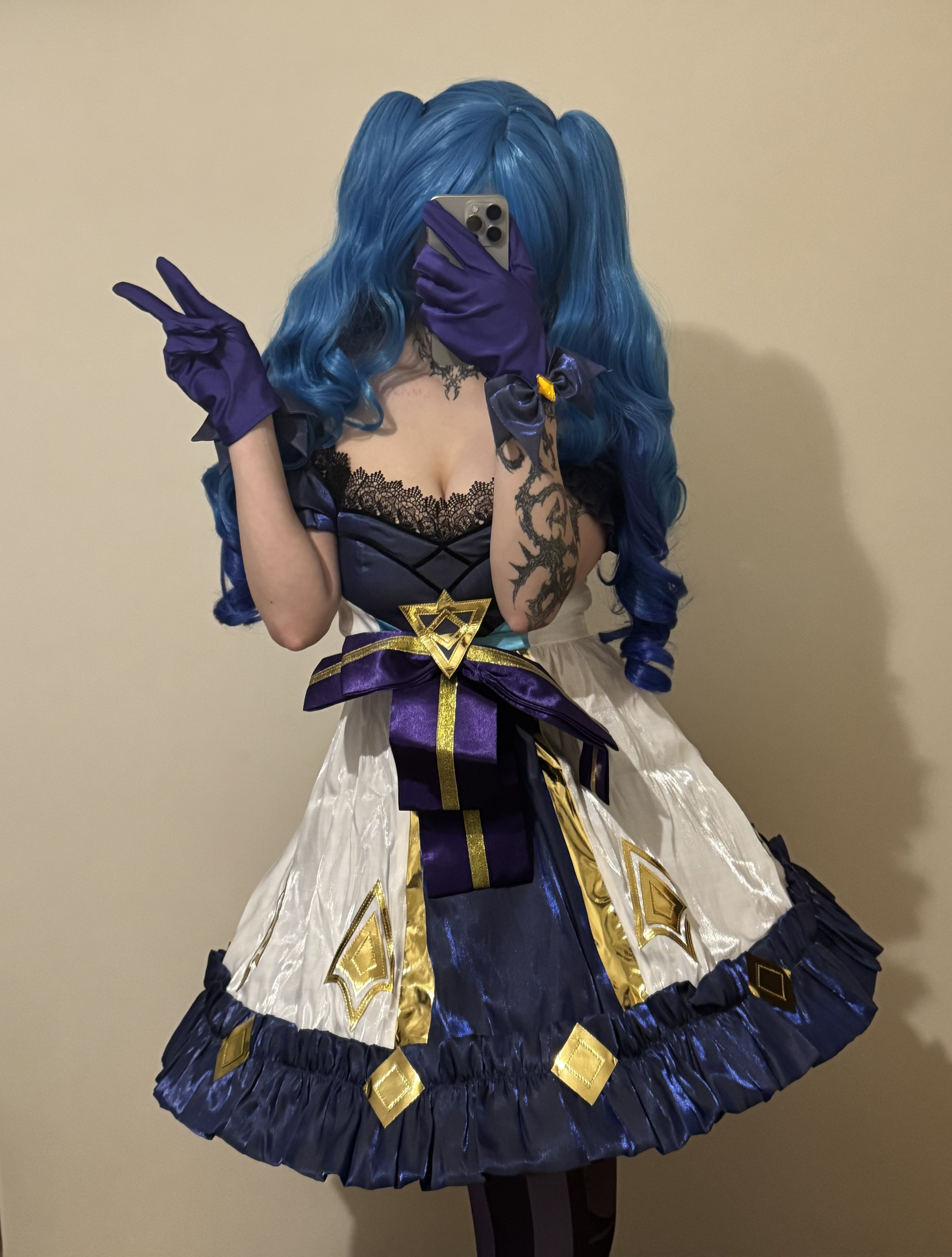 一位穿着蓝色裙子和紫色手套的女人拿着手机。