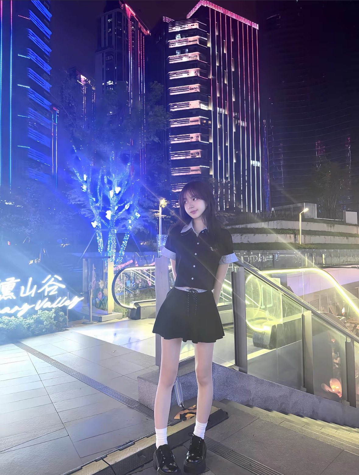 一位穿着黑色衬衫和蓝色的袖子的女人正在做和平的信号。