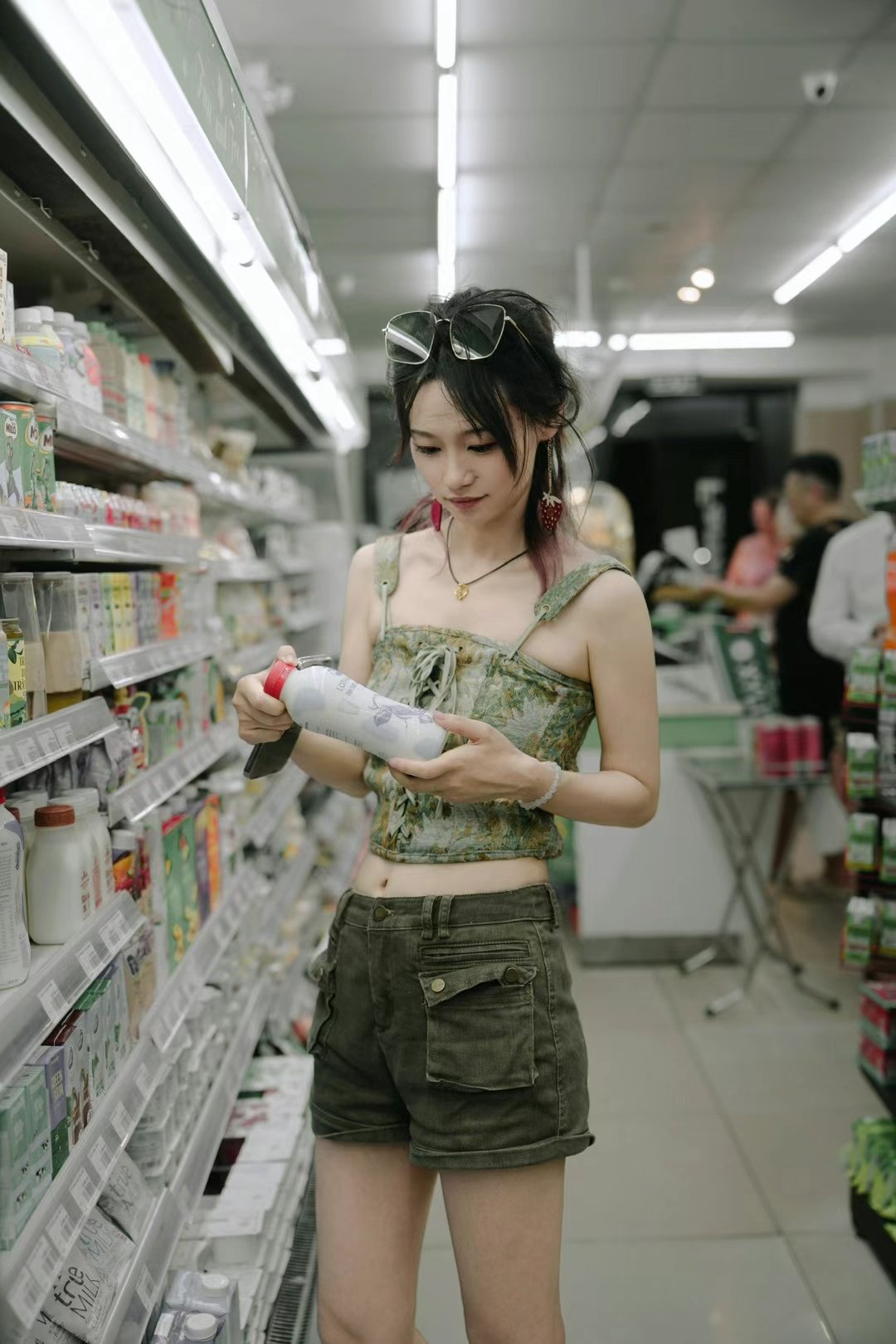 女人在一个杂货店里拿着一瓶奶油。