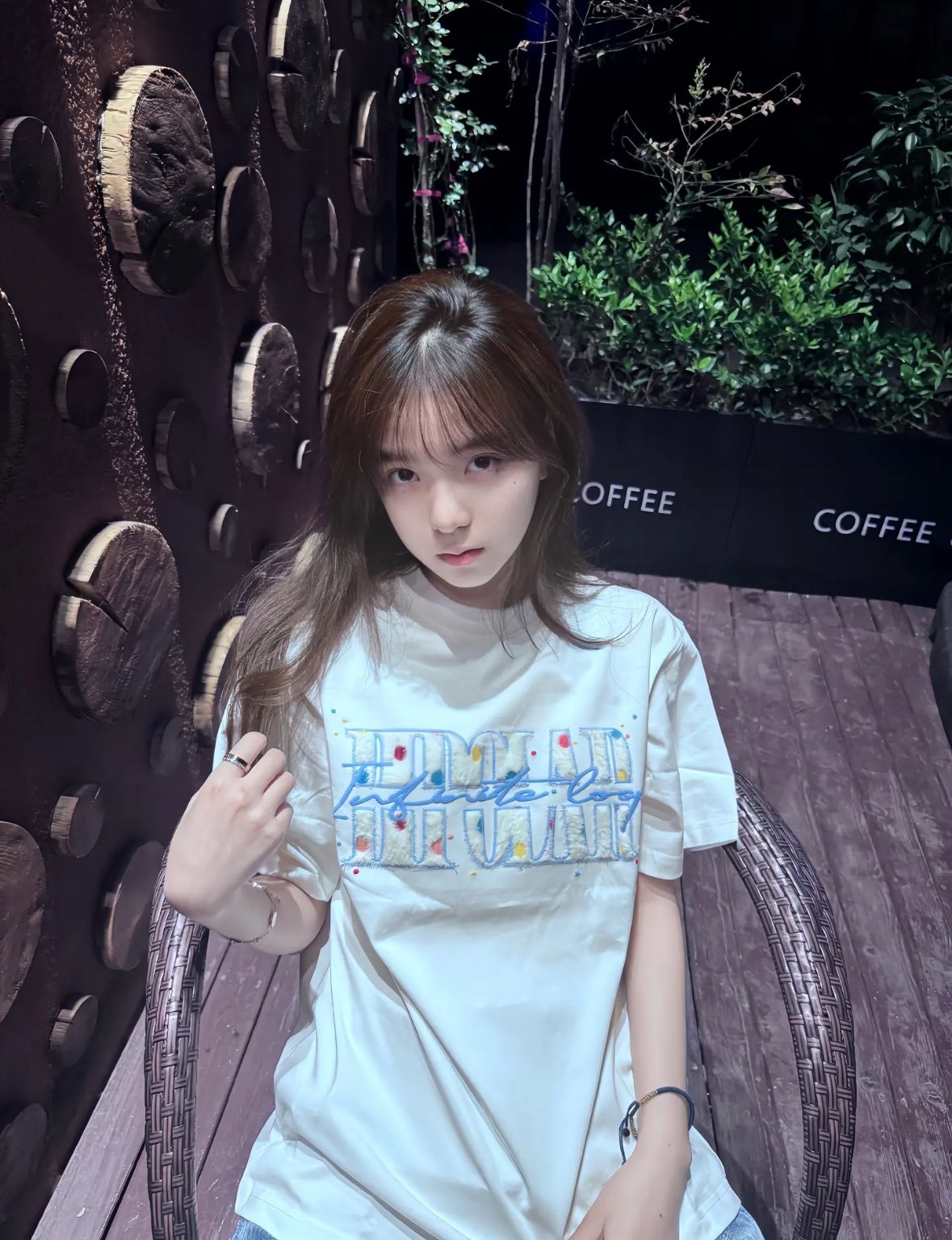 女人穿着一件白色衬衫,上面有一杯咖啡。