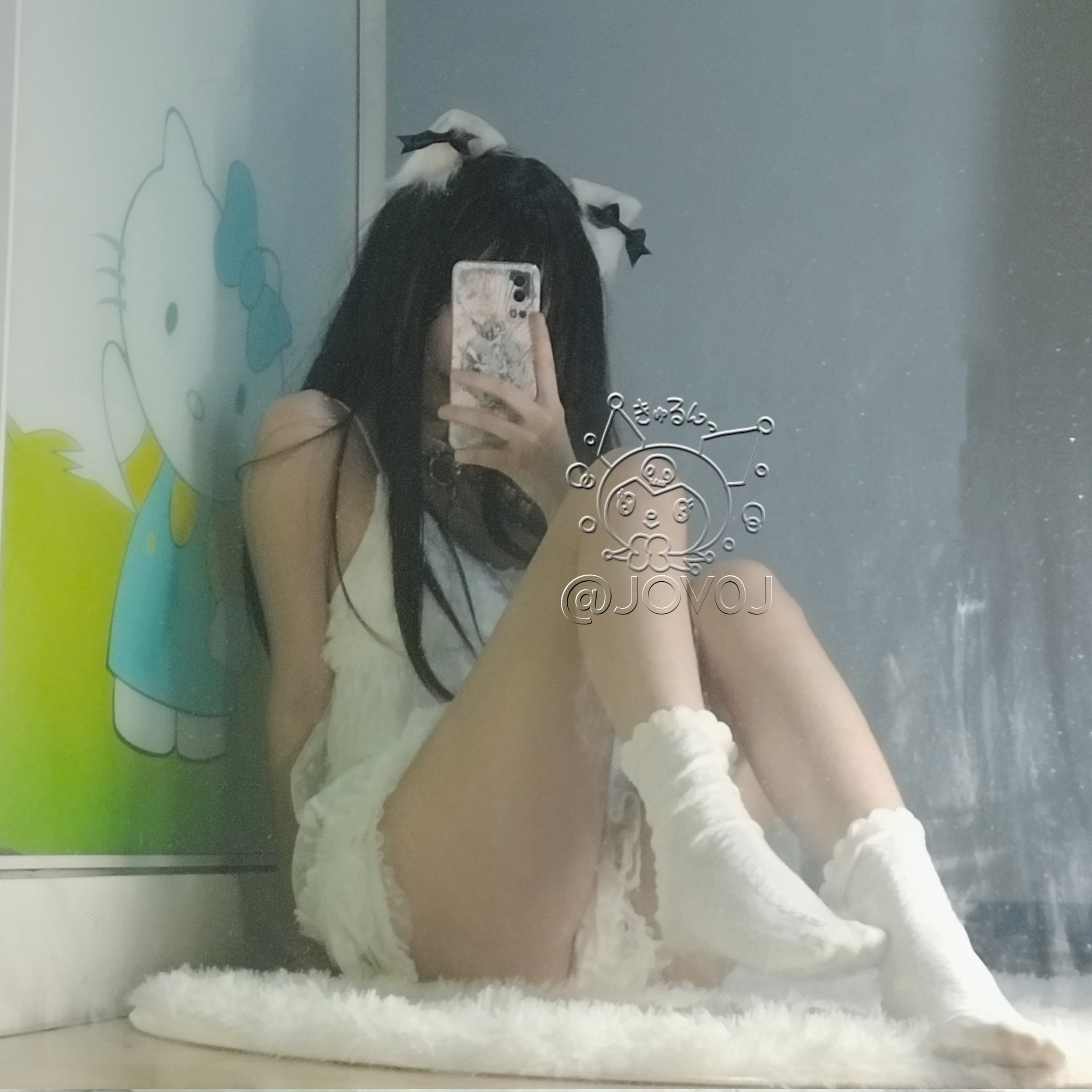 女孩在Hello Kitty的照片前拍自拍。