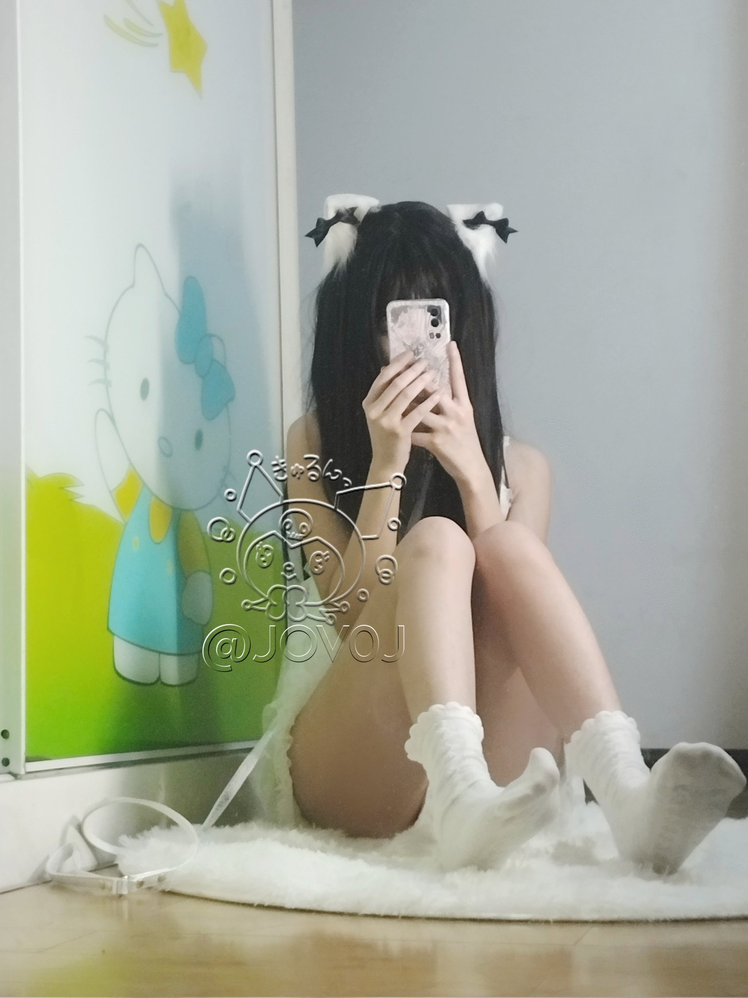 女孩在Hello Kitty的照片前拍自拍。