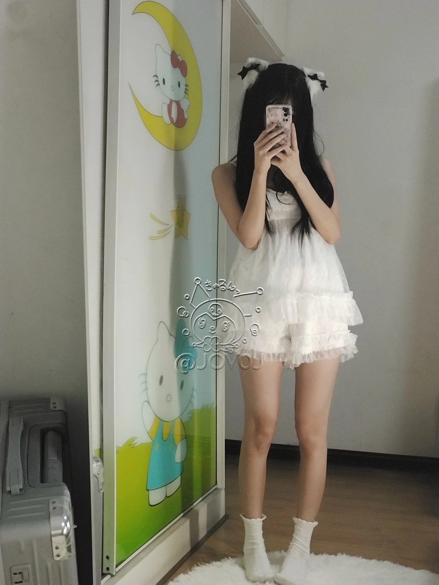 女孩在Hello Kitty的照片前拍自拍。